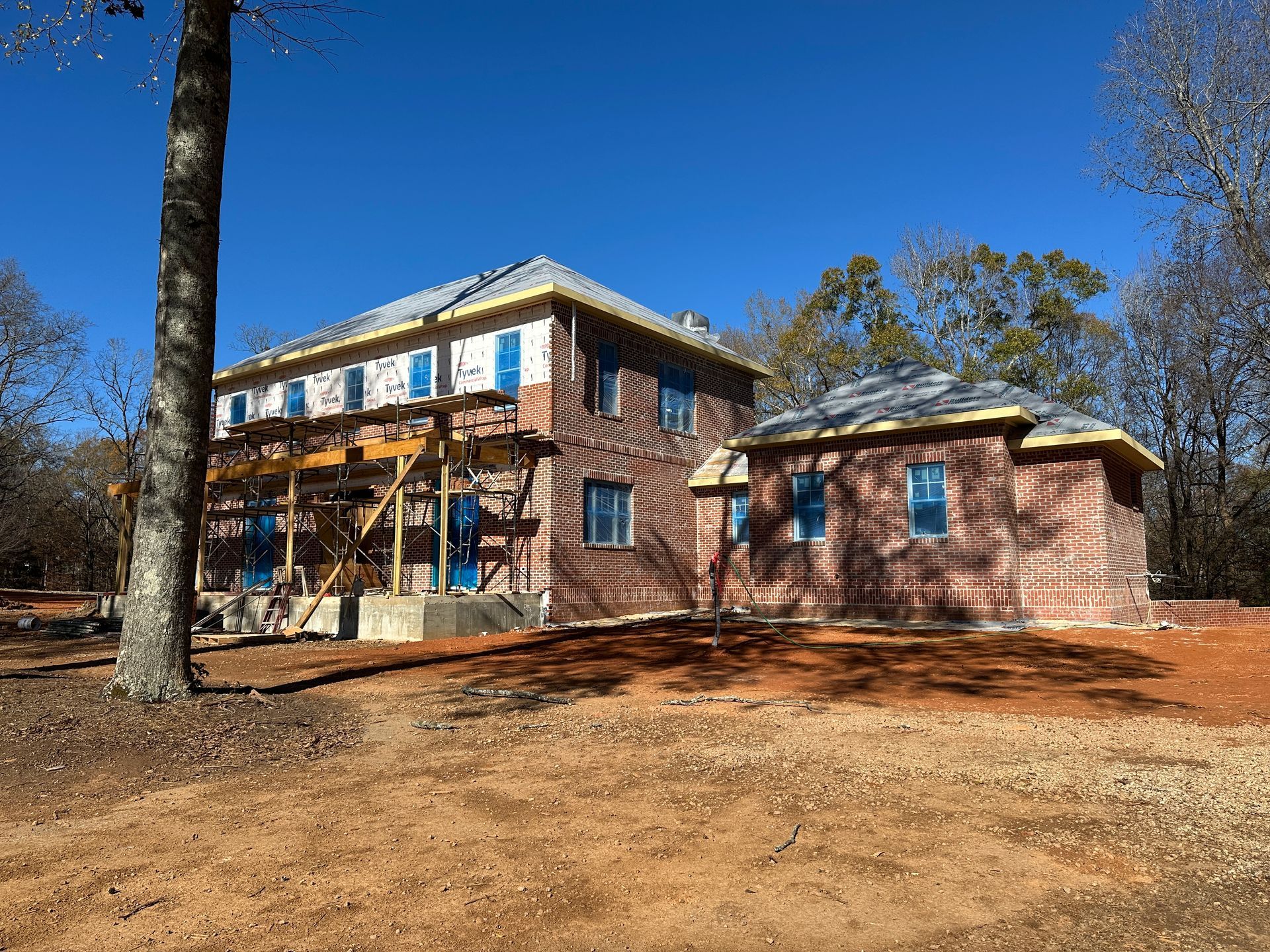 An aerial view of a new Hovey Precast office building with a blue roof surrounded by trees.