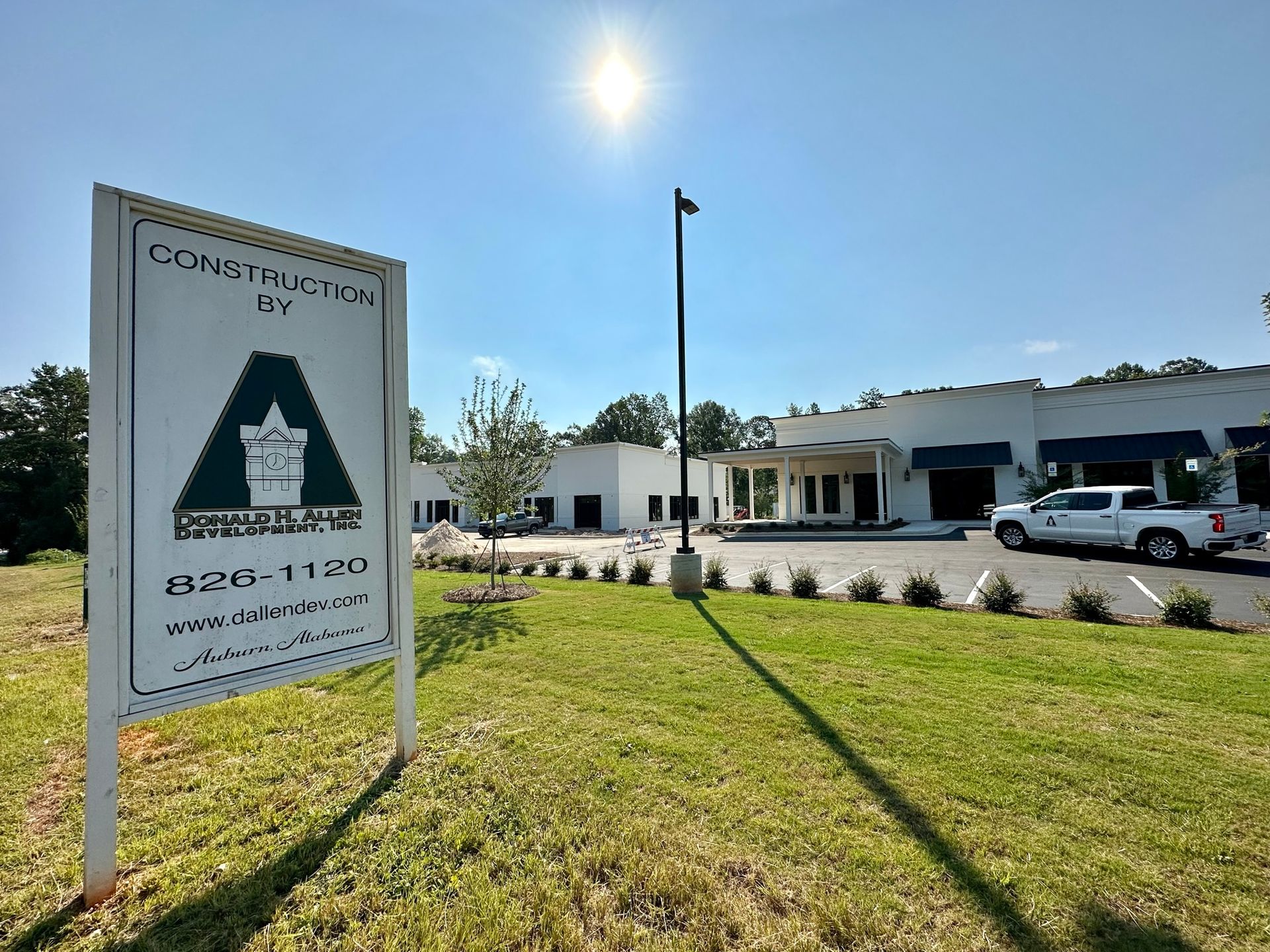 A sign for northside crossing is sitting in the middle of a grassy field.