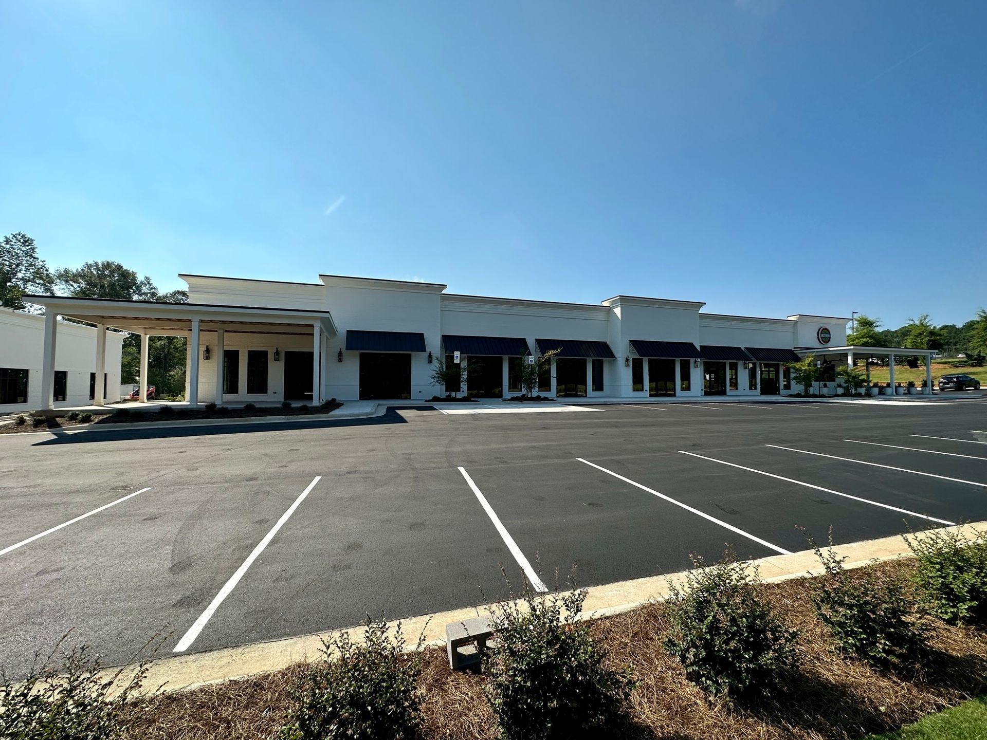 A large white building with a parking lot in front of it