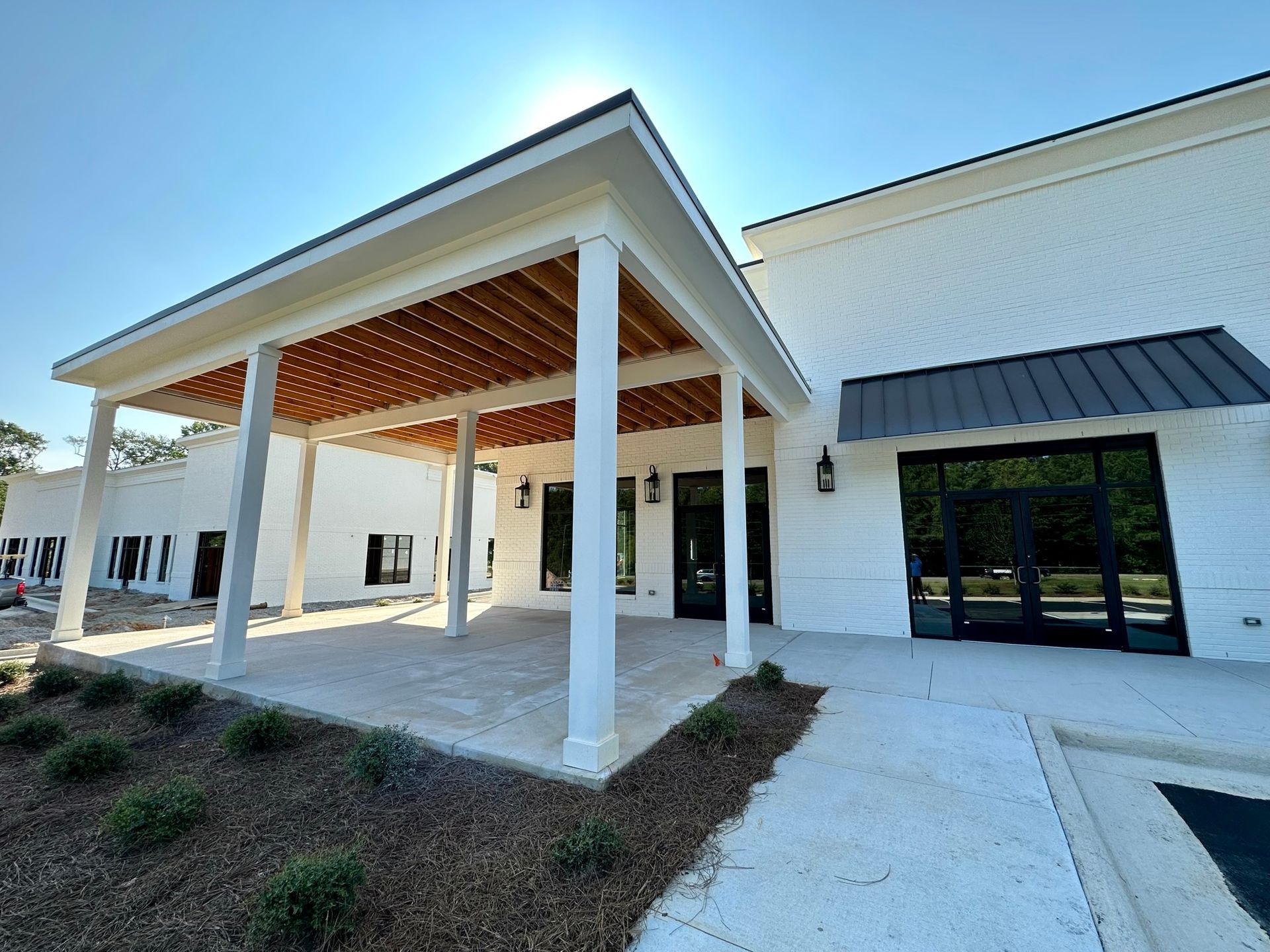 A large white building with a covered patio in front of it.