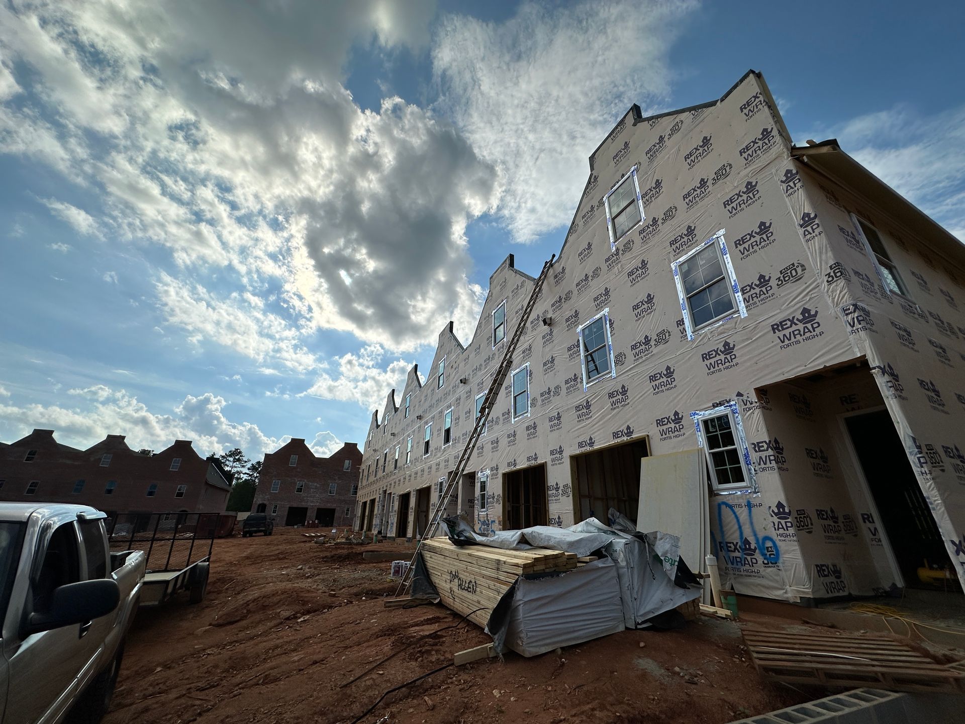 A large building under construction with a truck parked in front of it.