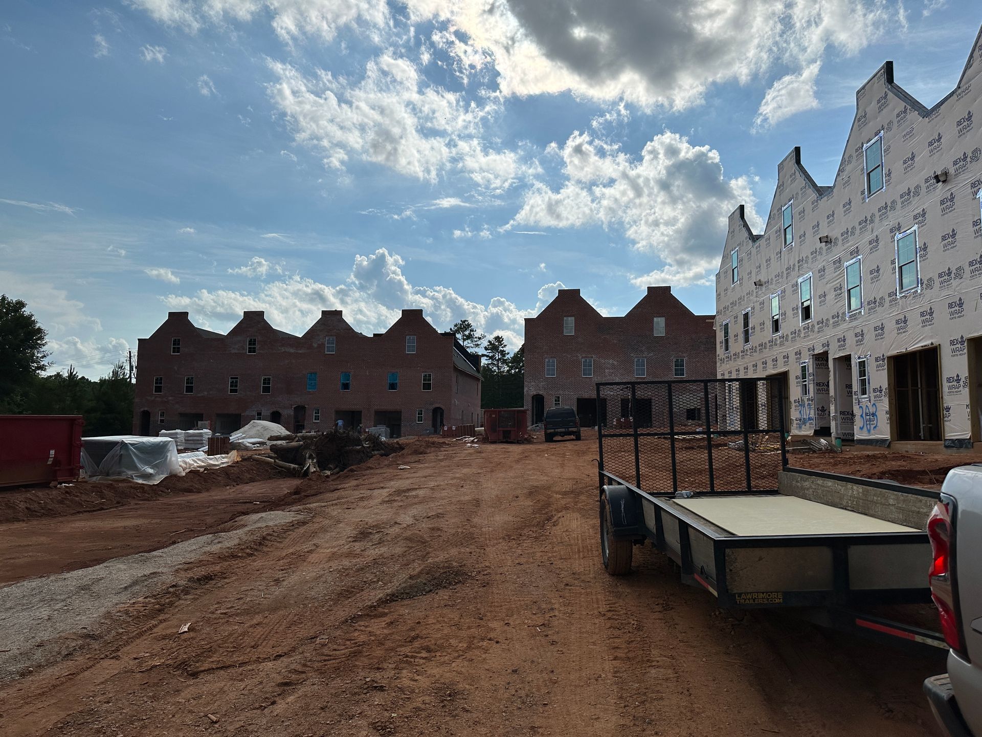A trailer is parked in front of a building under construction.