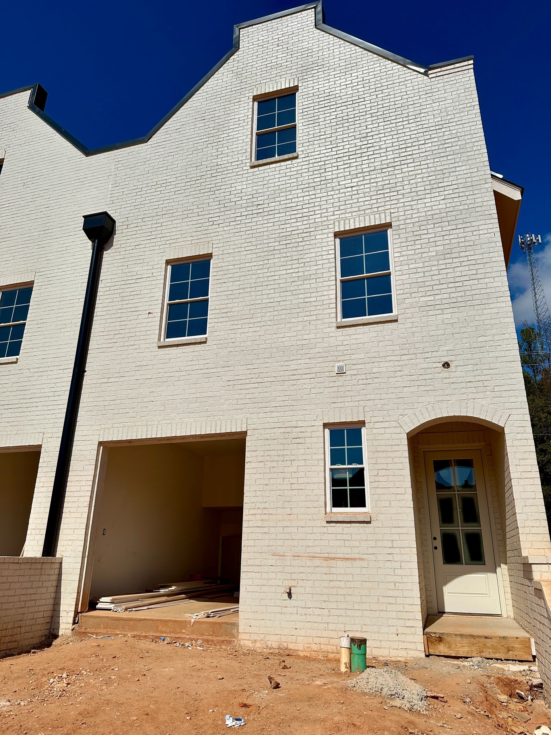 A white brick building with a blue sky in the background