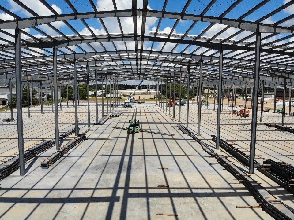 A large metal structure is under construction on a sunny day.