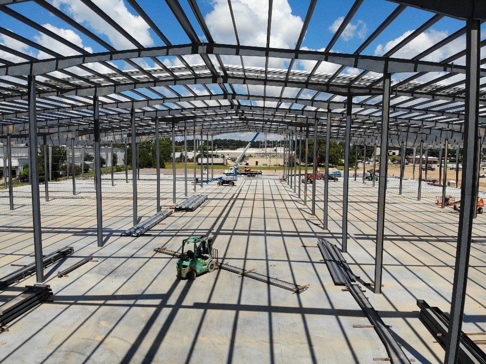 A large metal structure is being built on a sunny day.