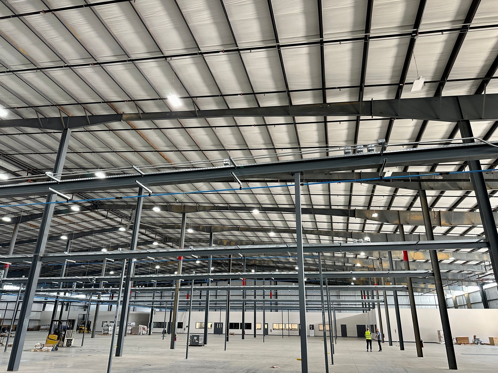 The inside of a large warehouse with a ceiling that is very high.