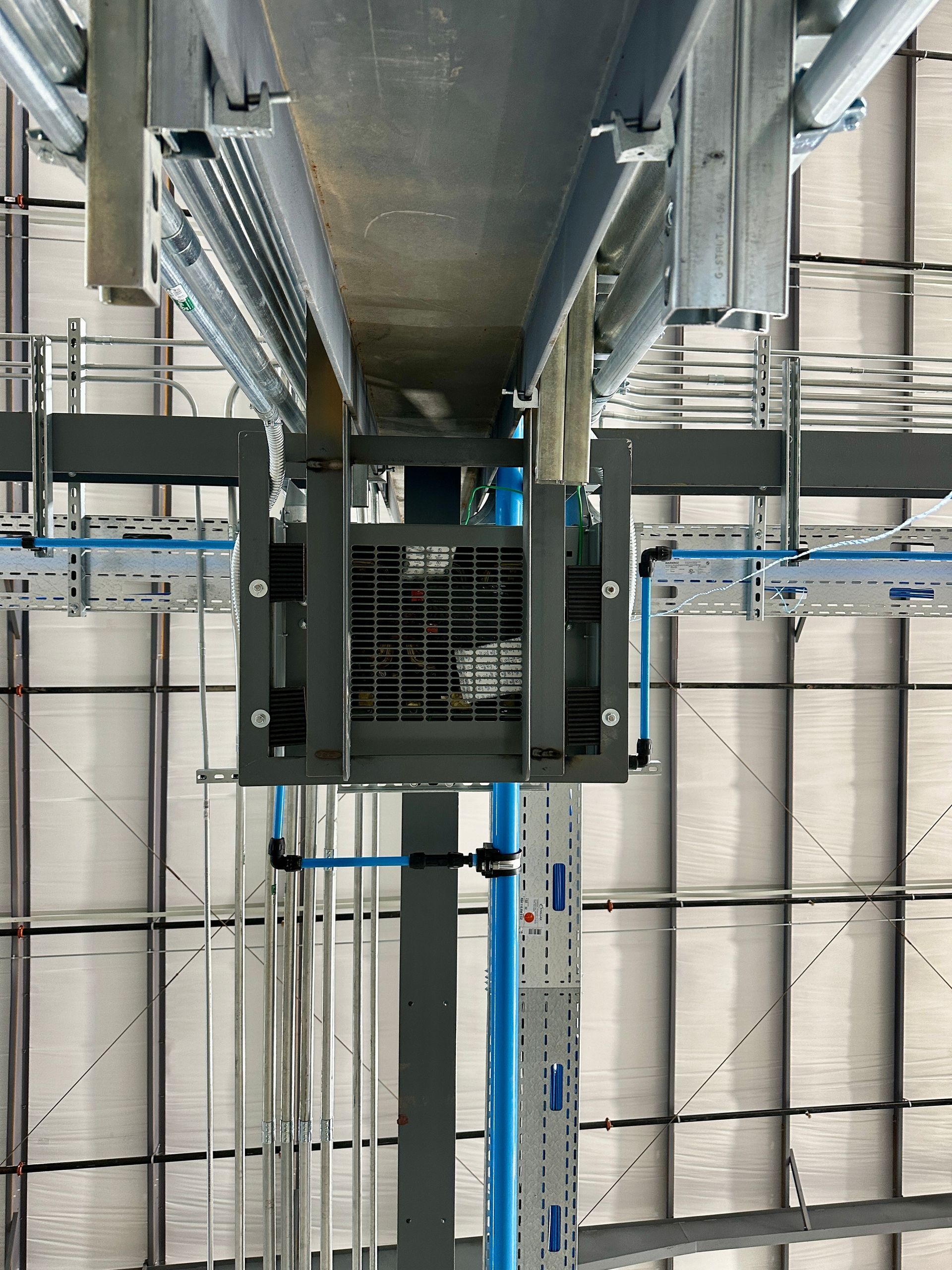 A blue pipe is hanging from the ceiling of a building