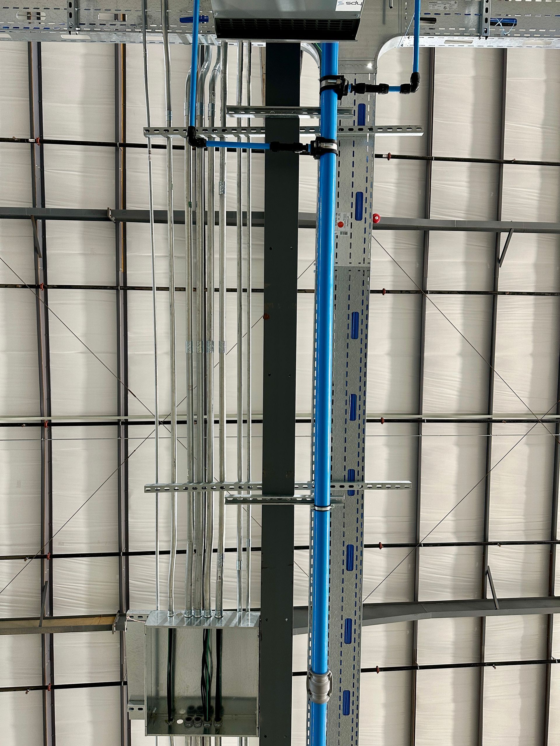 A blue pipe is hanging from the ceiling of a building