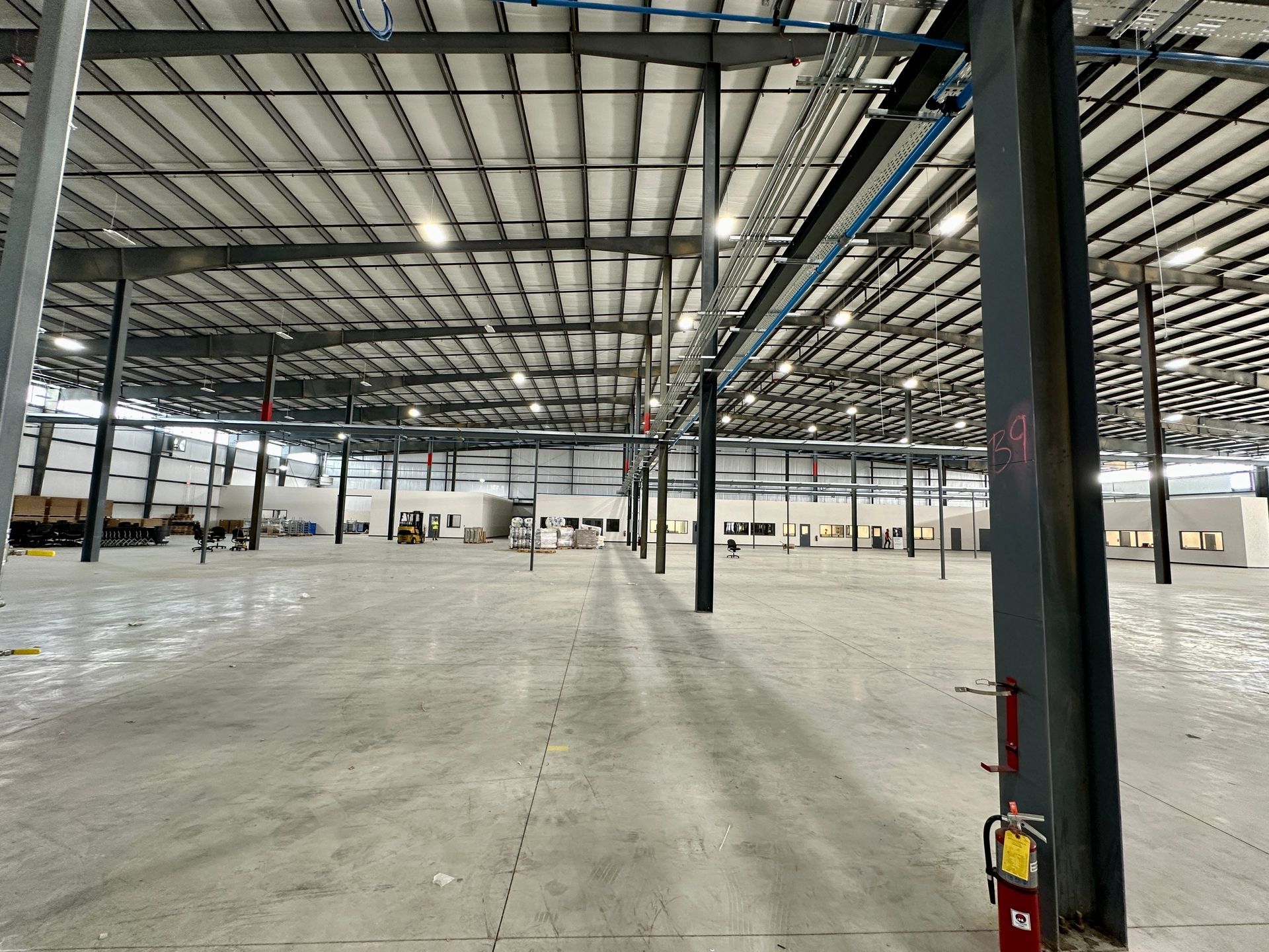 An empty warehouse with a fire extinguisher on the side