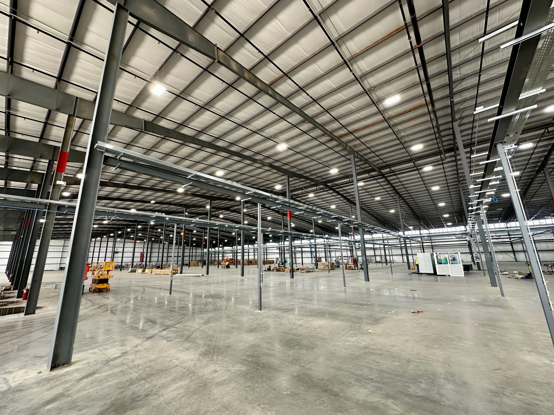 A large empty warehouse with a lot of lights on the ceiling