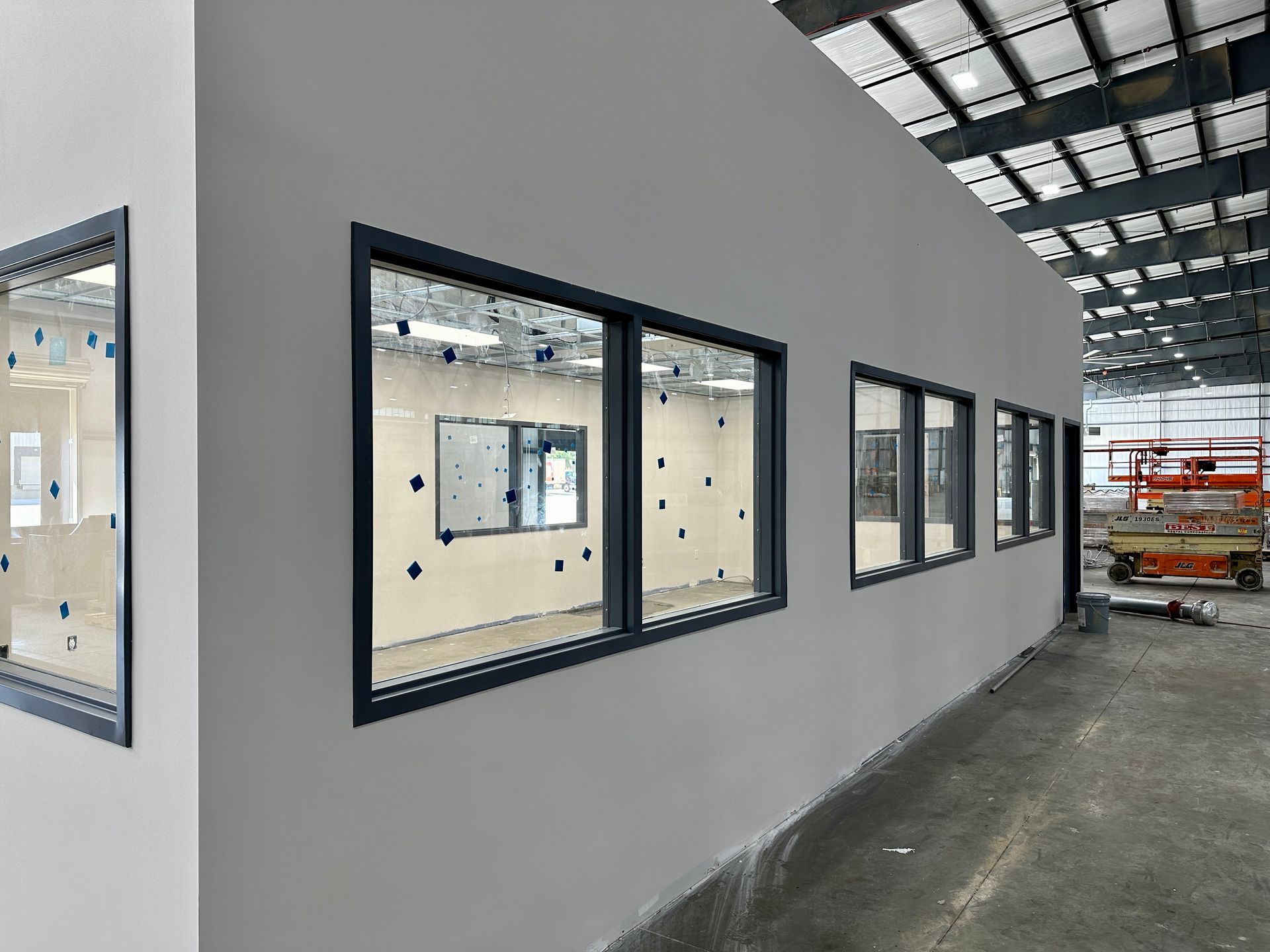 A row of windows on a wall in a building under construction.