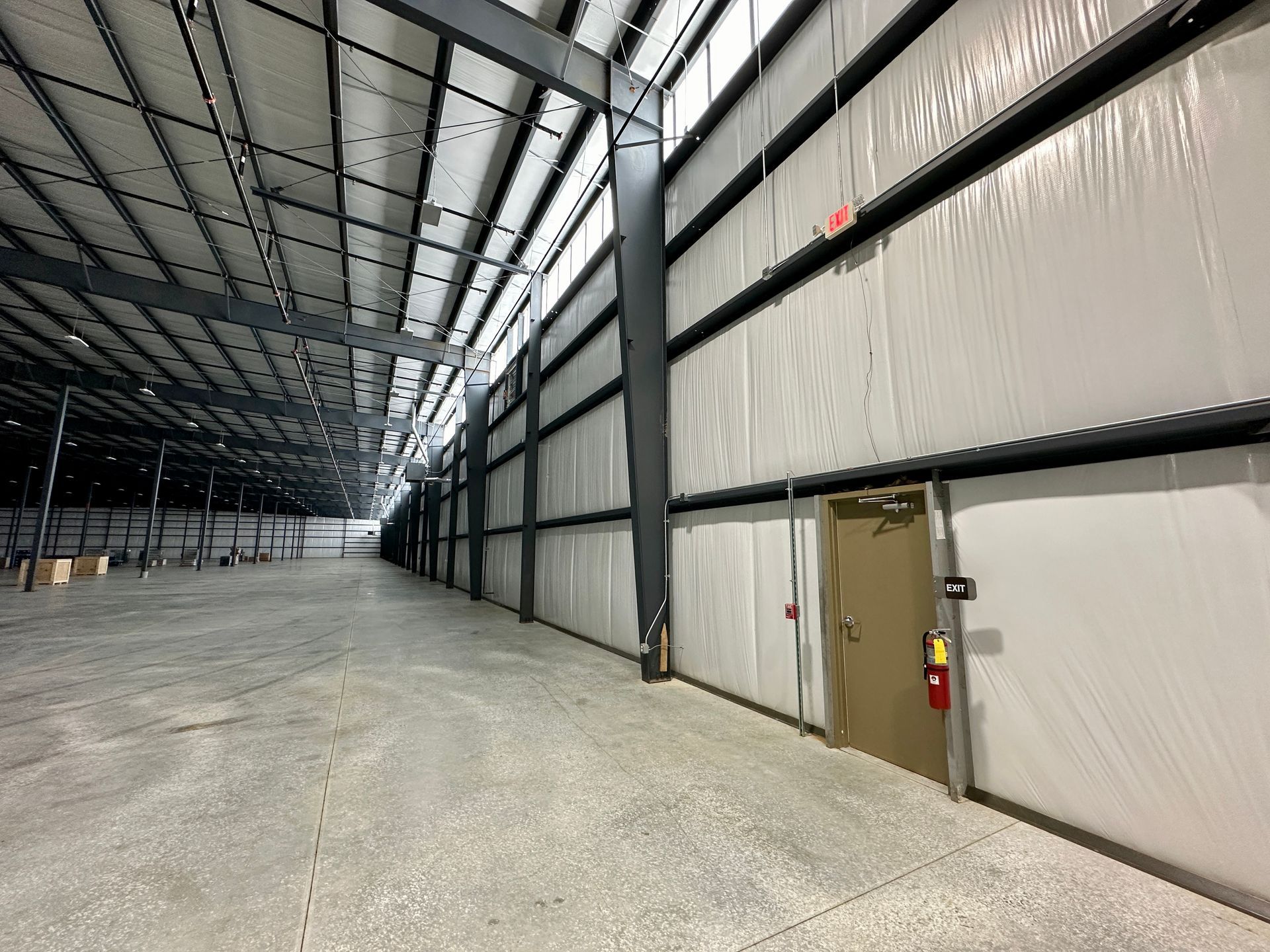 An empty warehouse with a door in the middle of it.