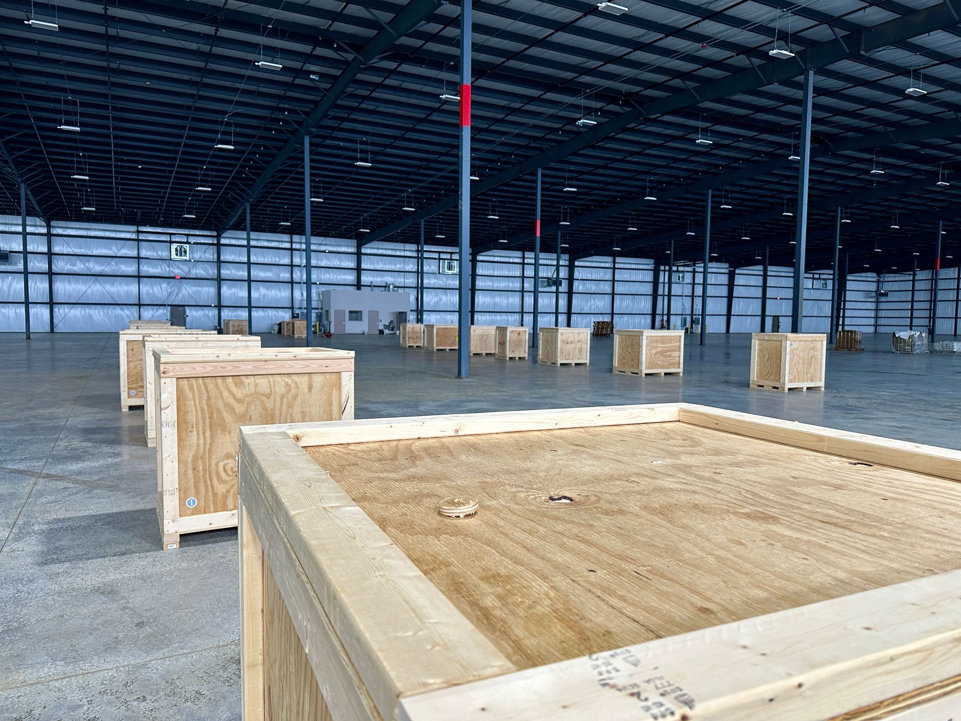 A warehouse filled with wooden crates and pallets.