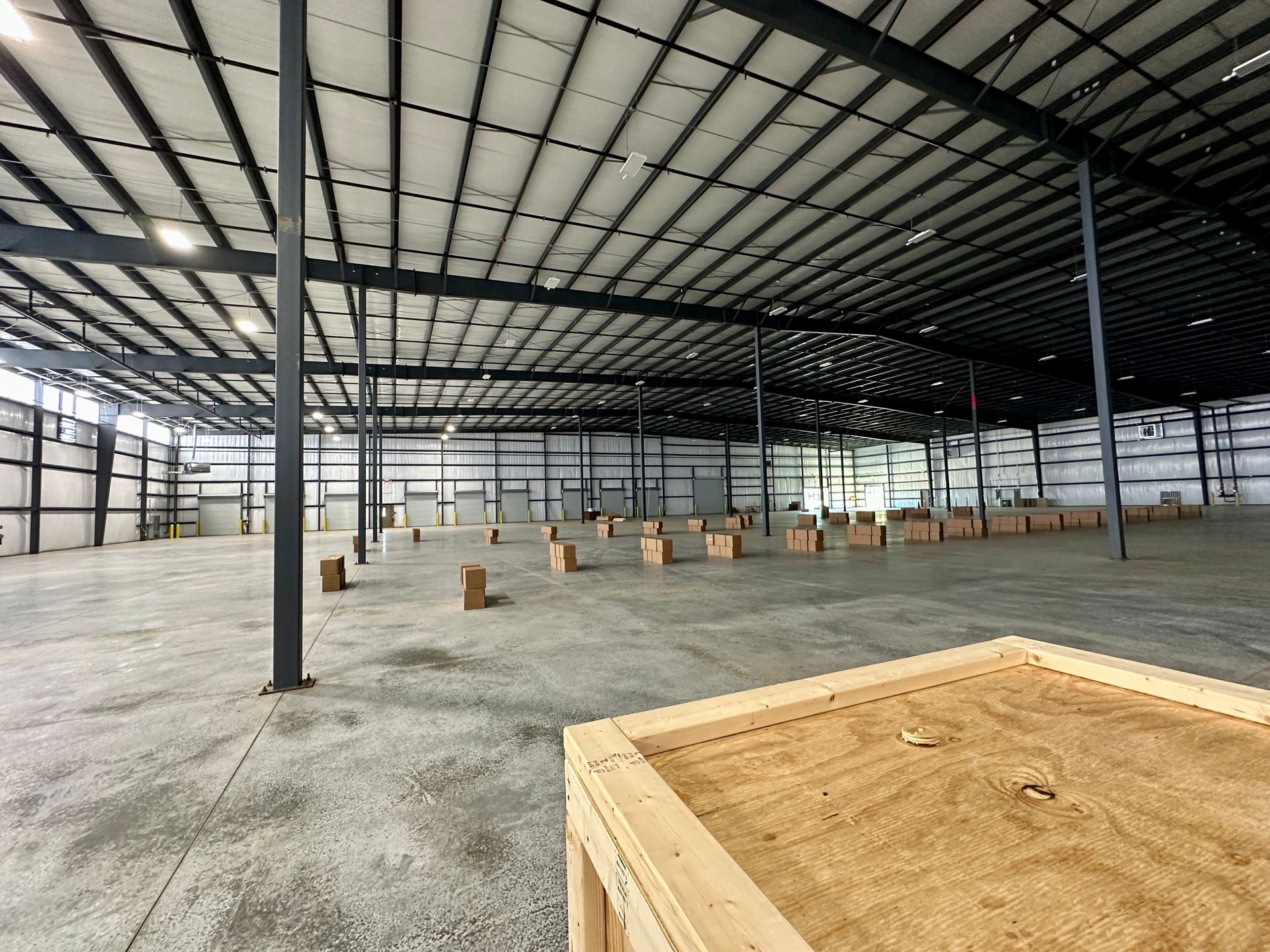 A large empty warehouse with a wooden box in the foreground