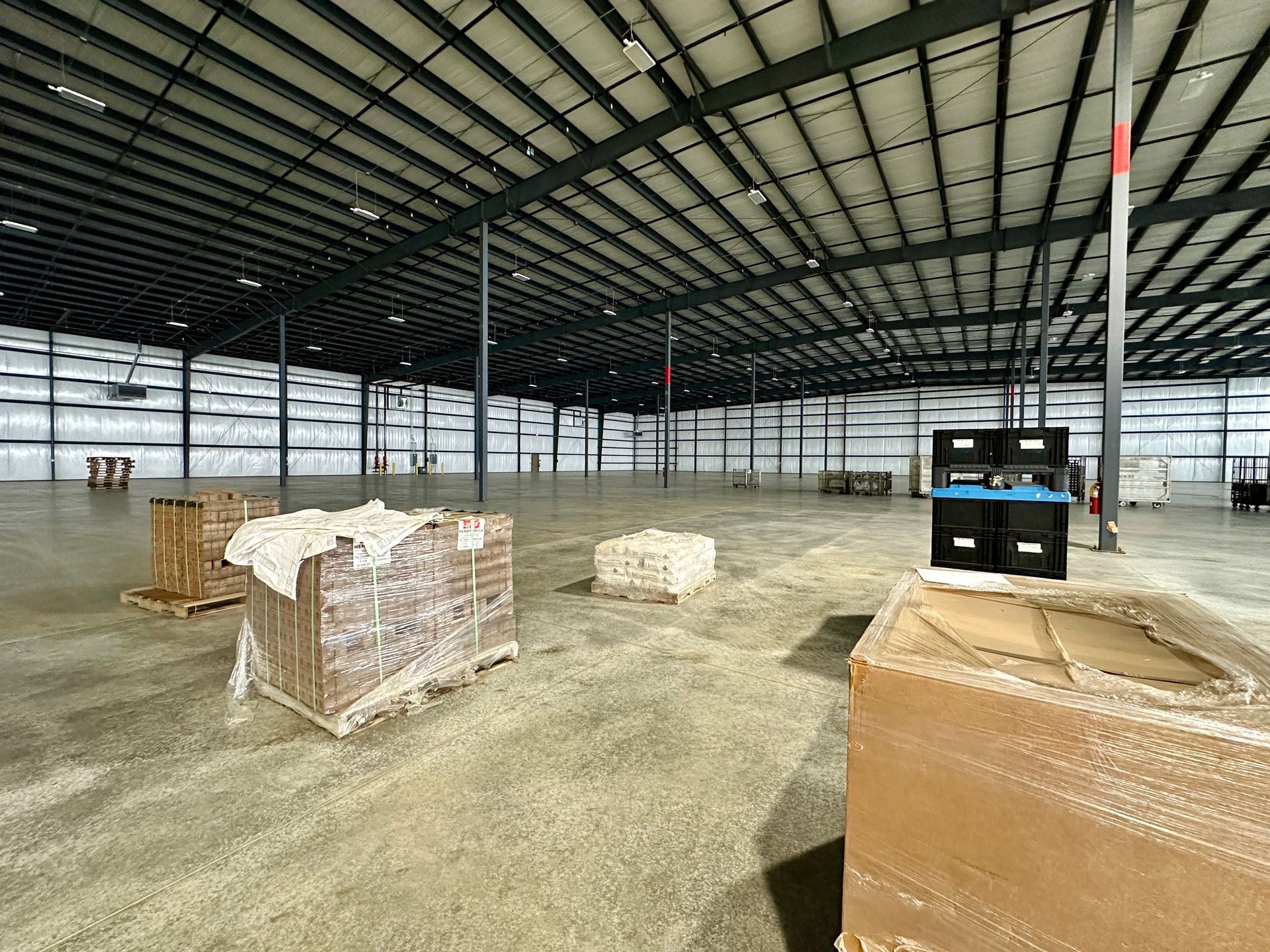 A large warehouse filled with lots of boxes and pallets.