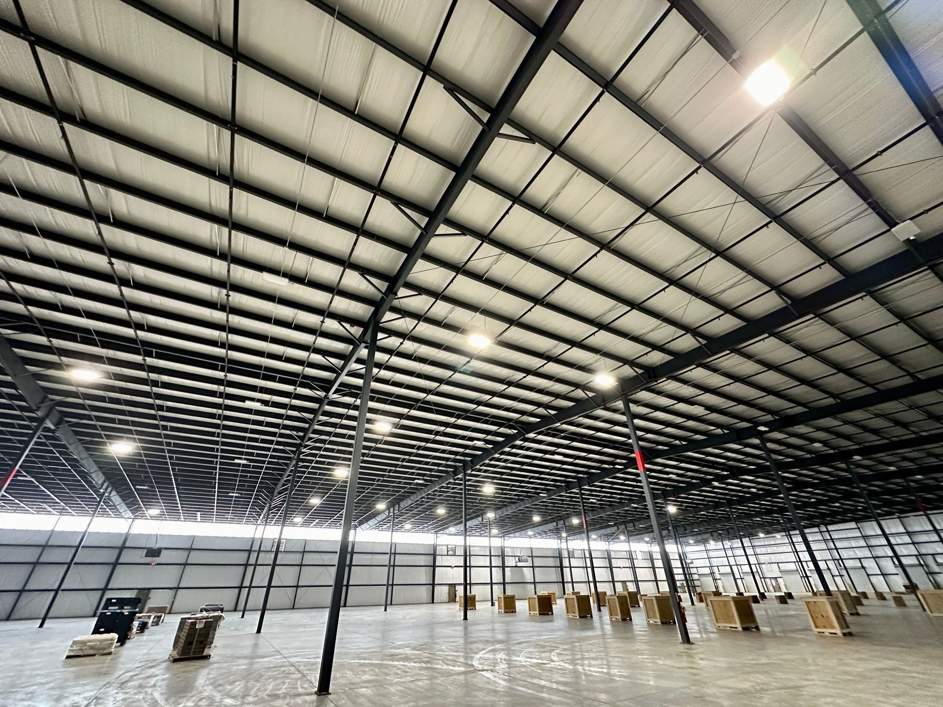 The inside of a large warehouse with lots of lights on the ceiling.
