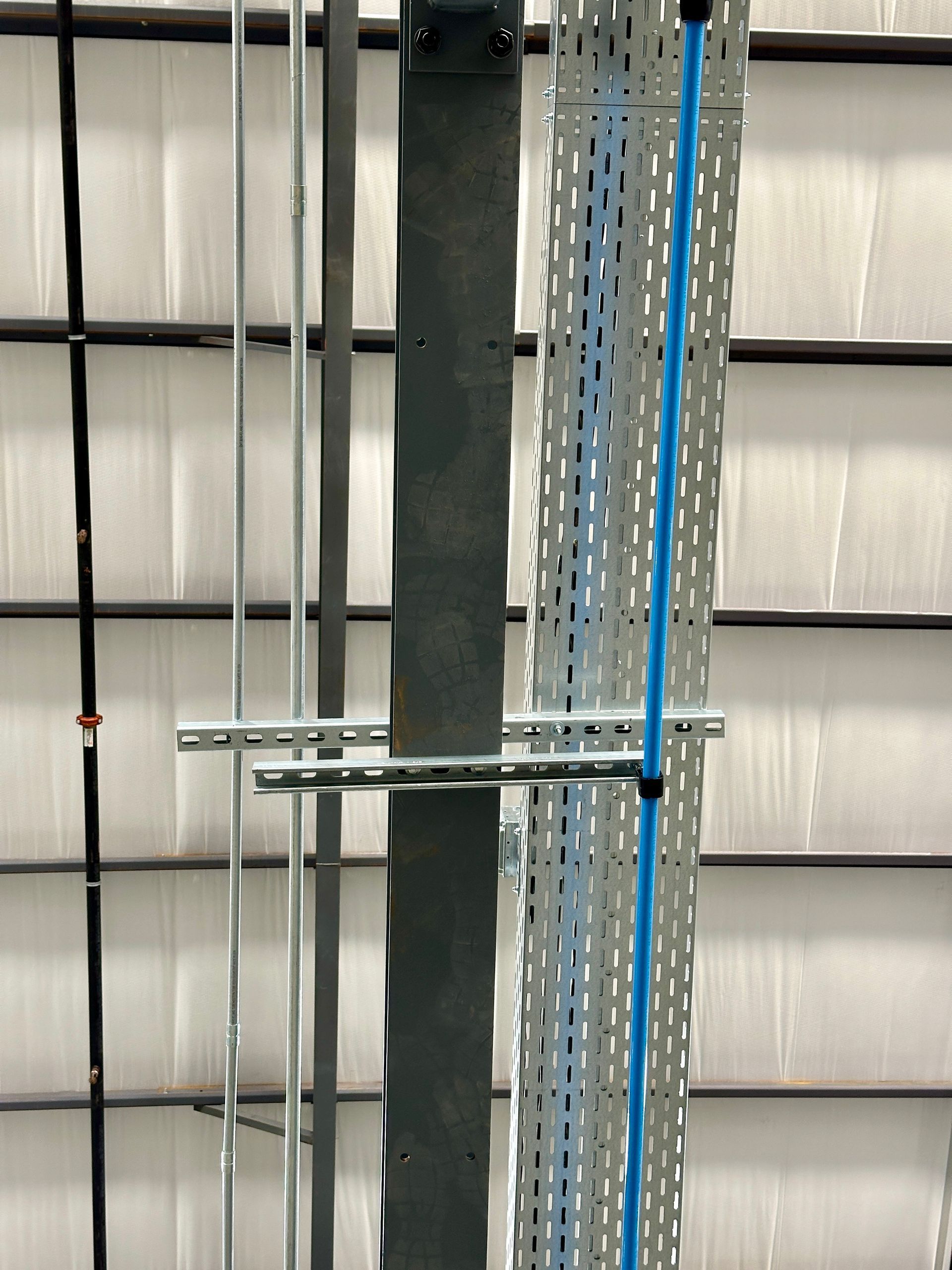 A bunch of wires are hanging from the ceiling of a building