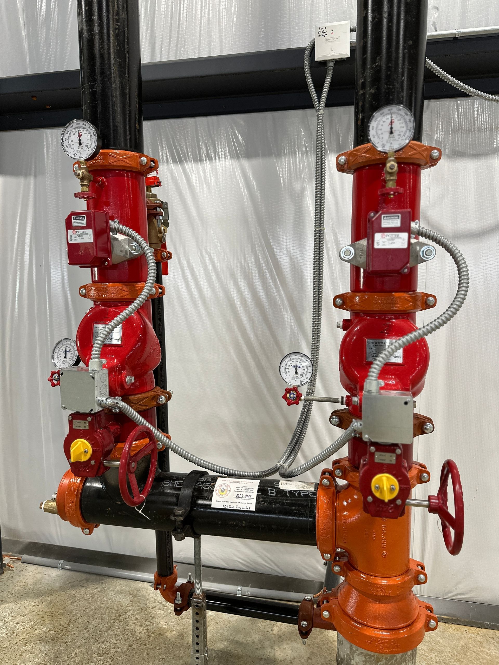 A couple of red pipes with gauges attached to them.