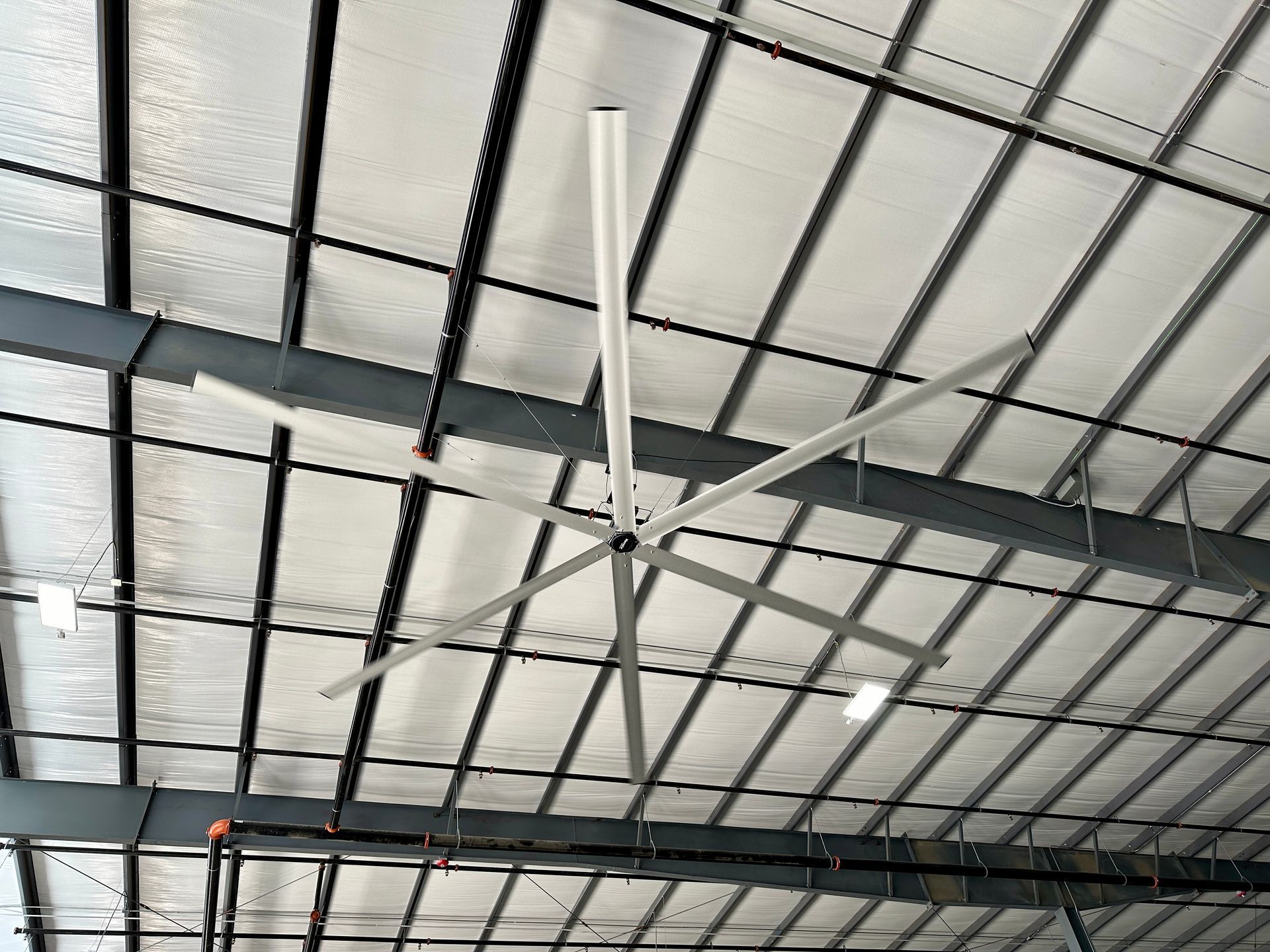 A large ceiling fan is hanging from the ceiling of a building.