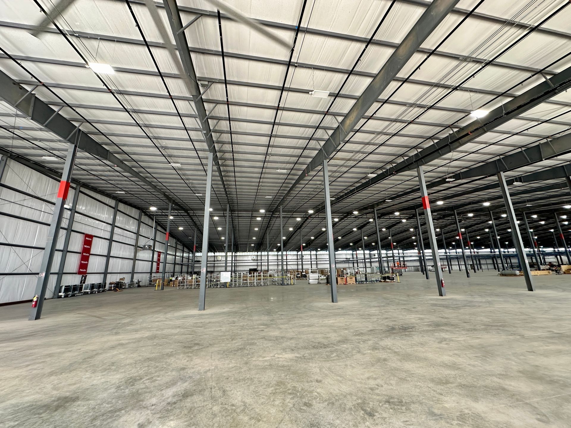 The inside of a large warehouse with a lot of empty space.