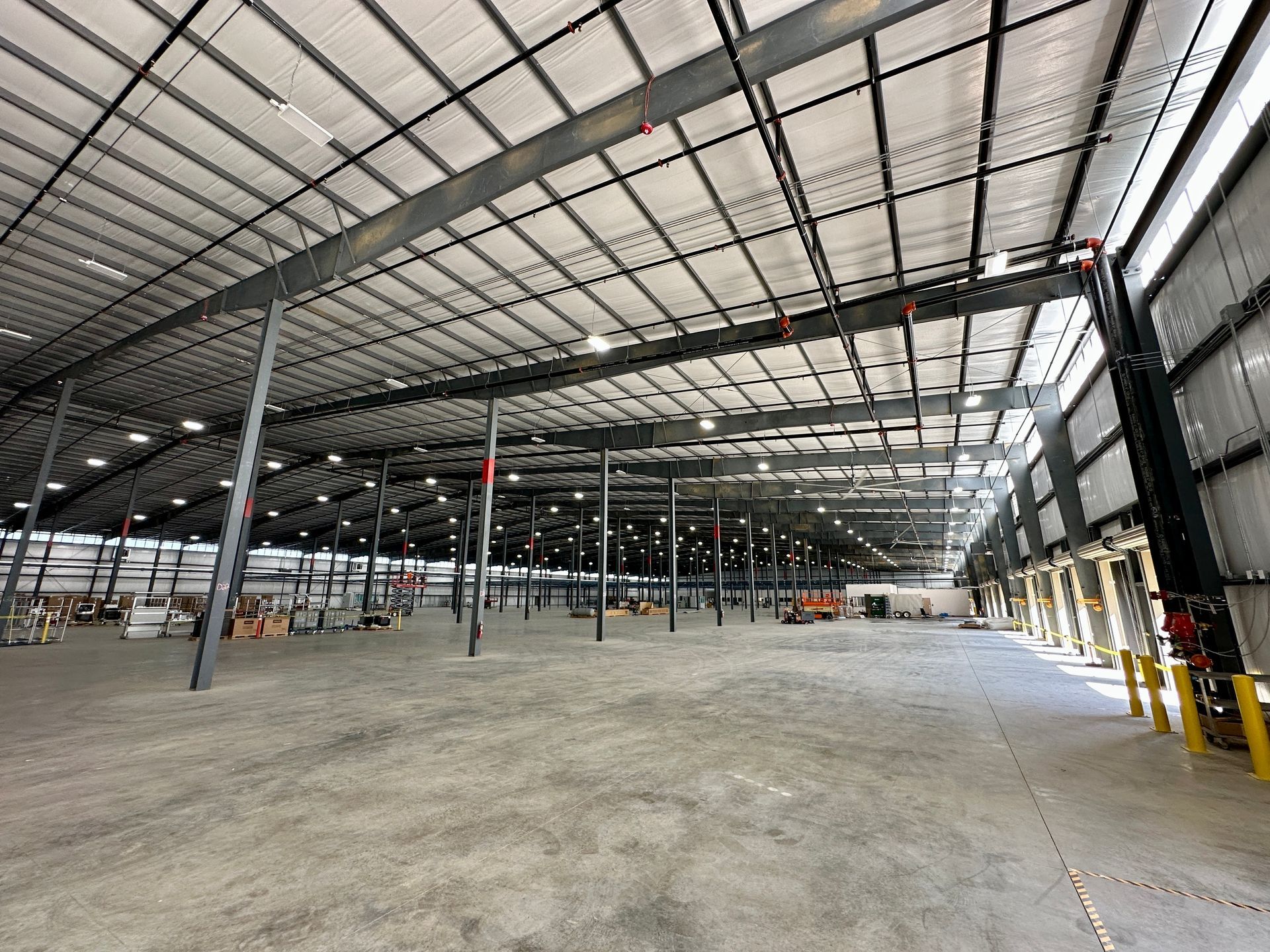 A large warehouse with a lot of windows and a concrete floor.