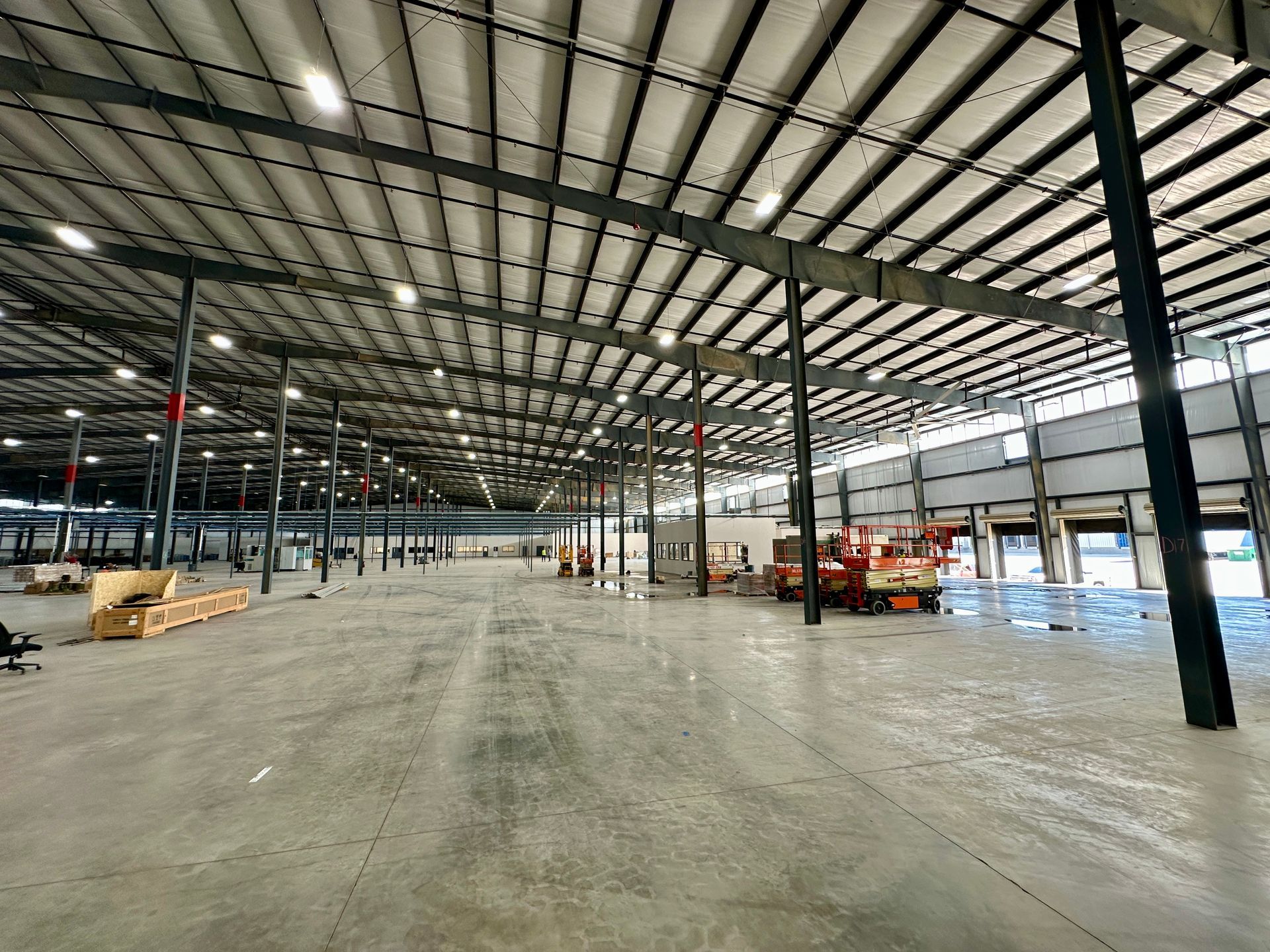 A large warehouse with a concrete floor and a metal roof.