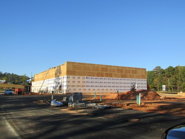 A large building is being built in a parking lot