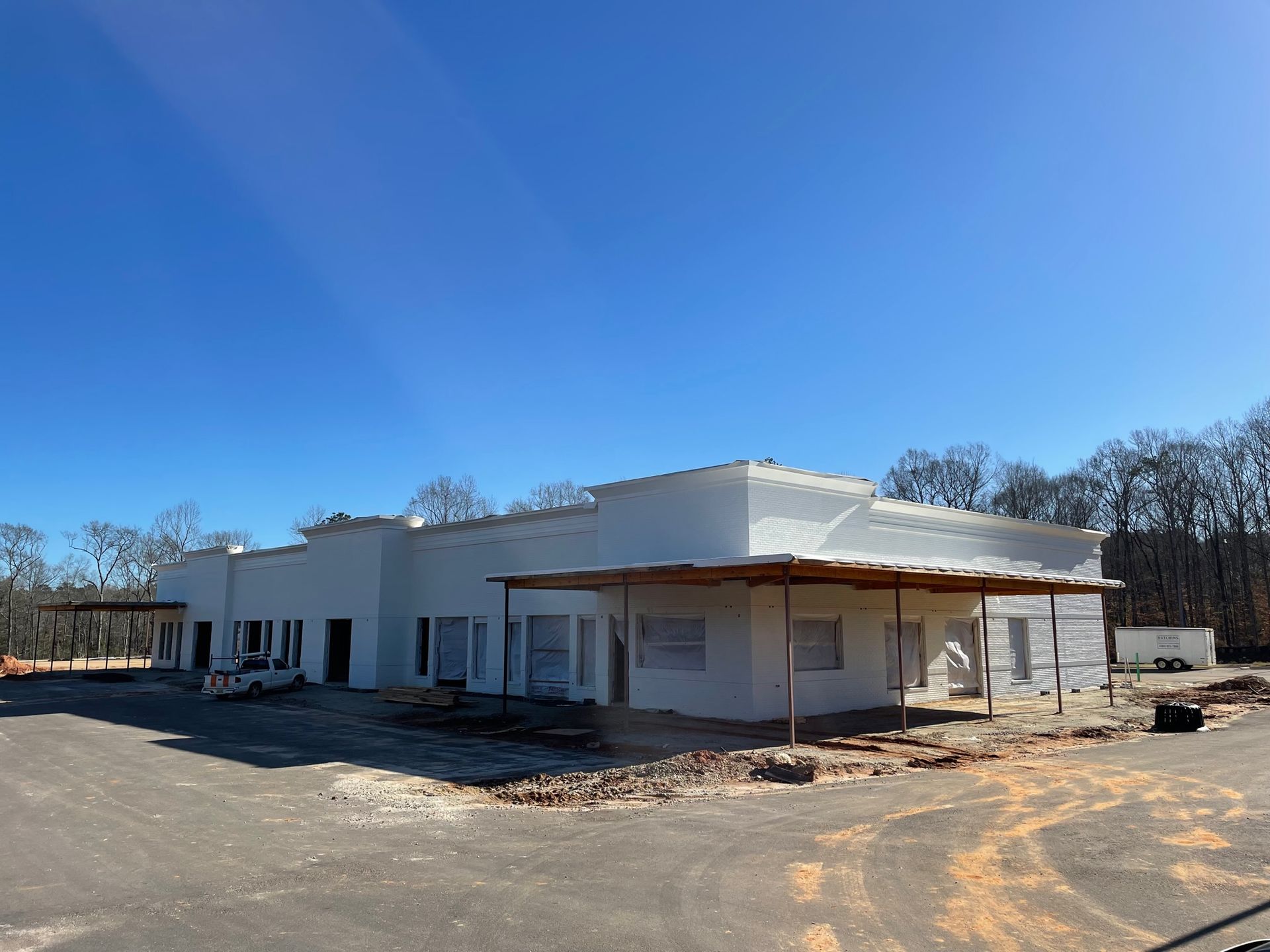 A large white building under construction with a blue sky in the background.