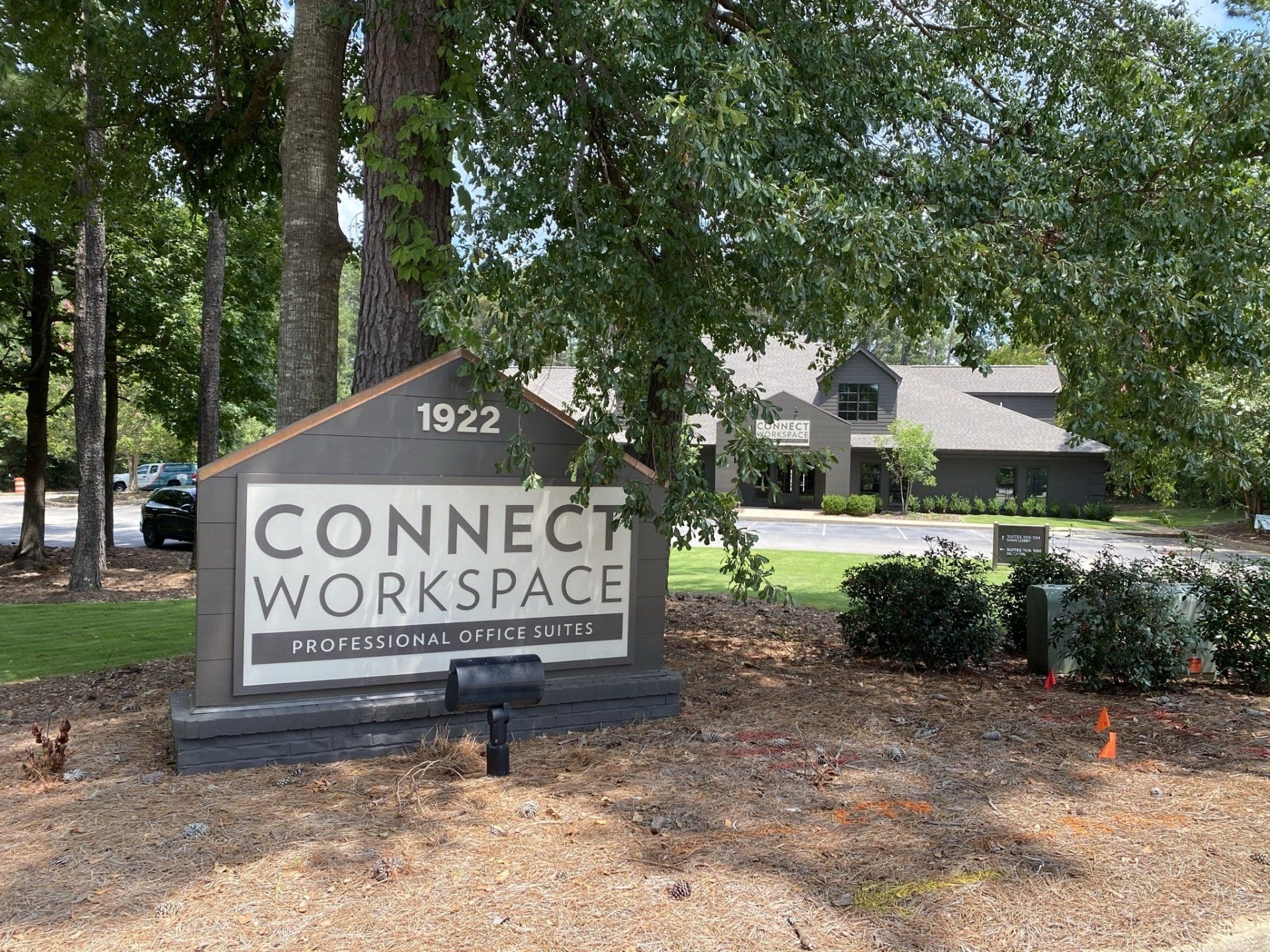 A sign for connect workspace is in front of a building.