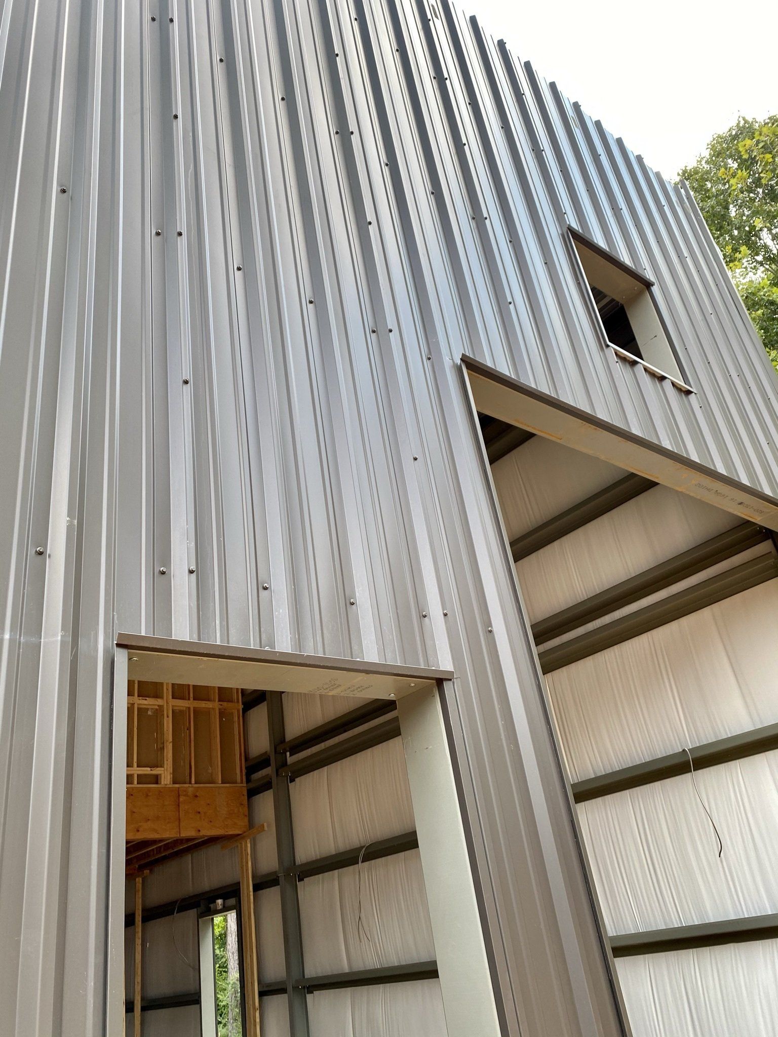 A building under construction with a metal roof and a window