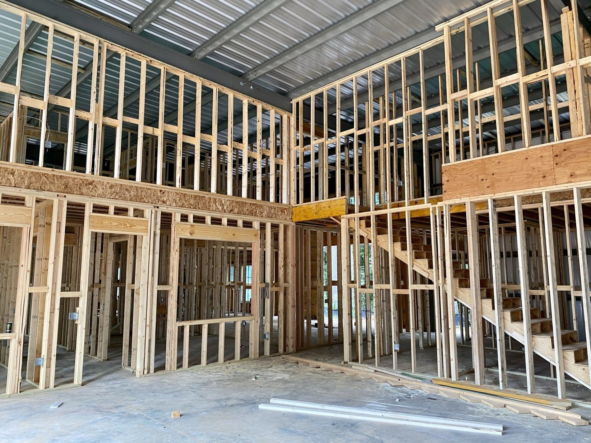 The inside of a building under construction with wooden frames and stairs.