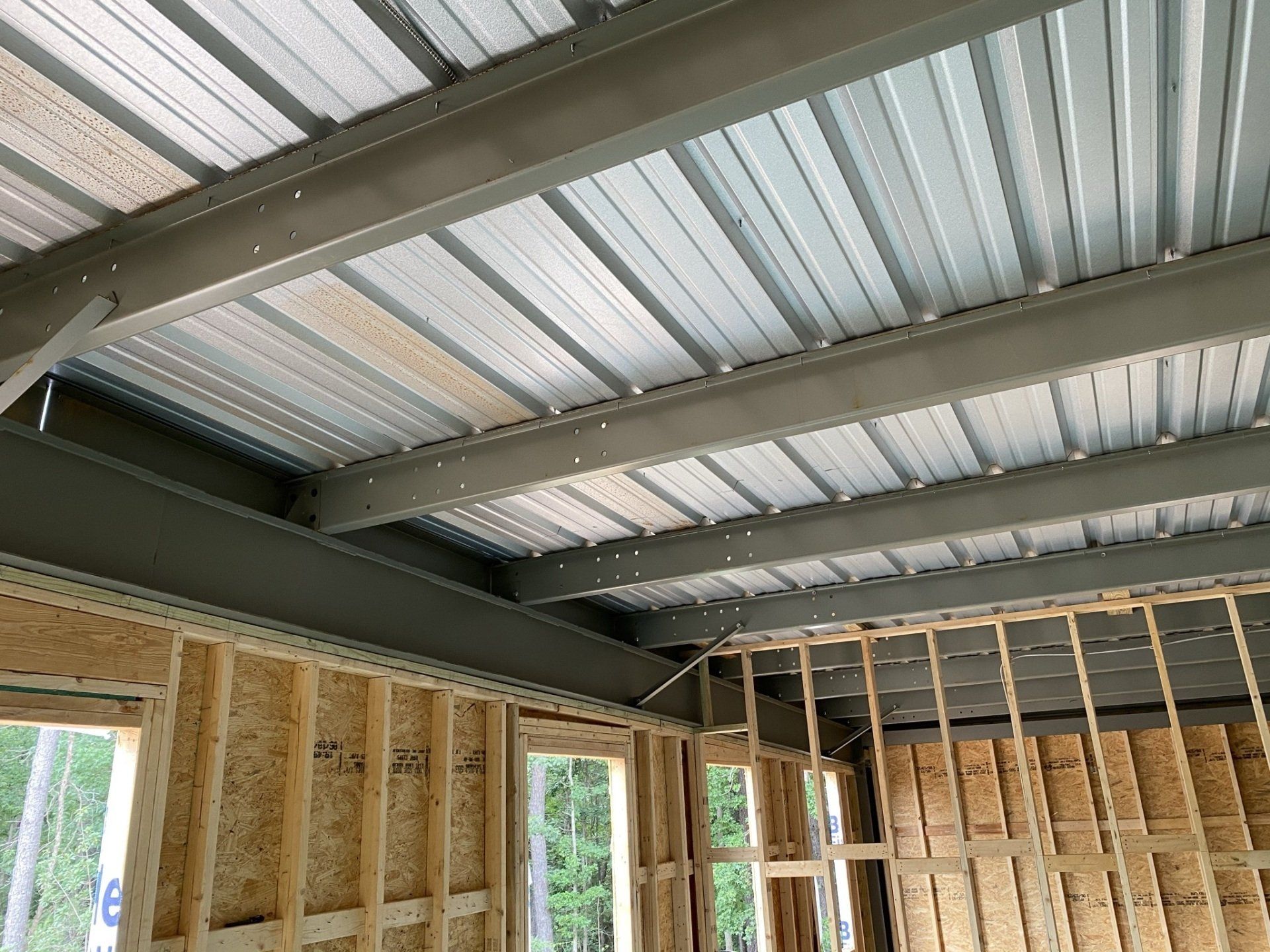 A building under construction with a metal roof and wooden walls.