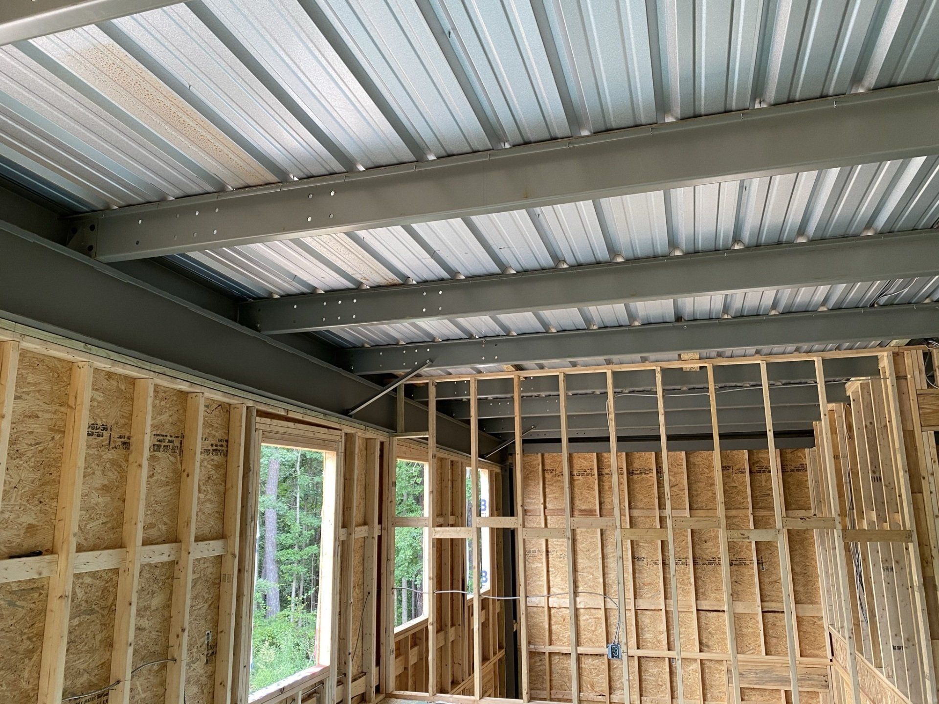 A room with a metal ceiling and wooden walls under construction.
