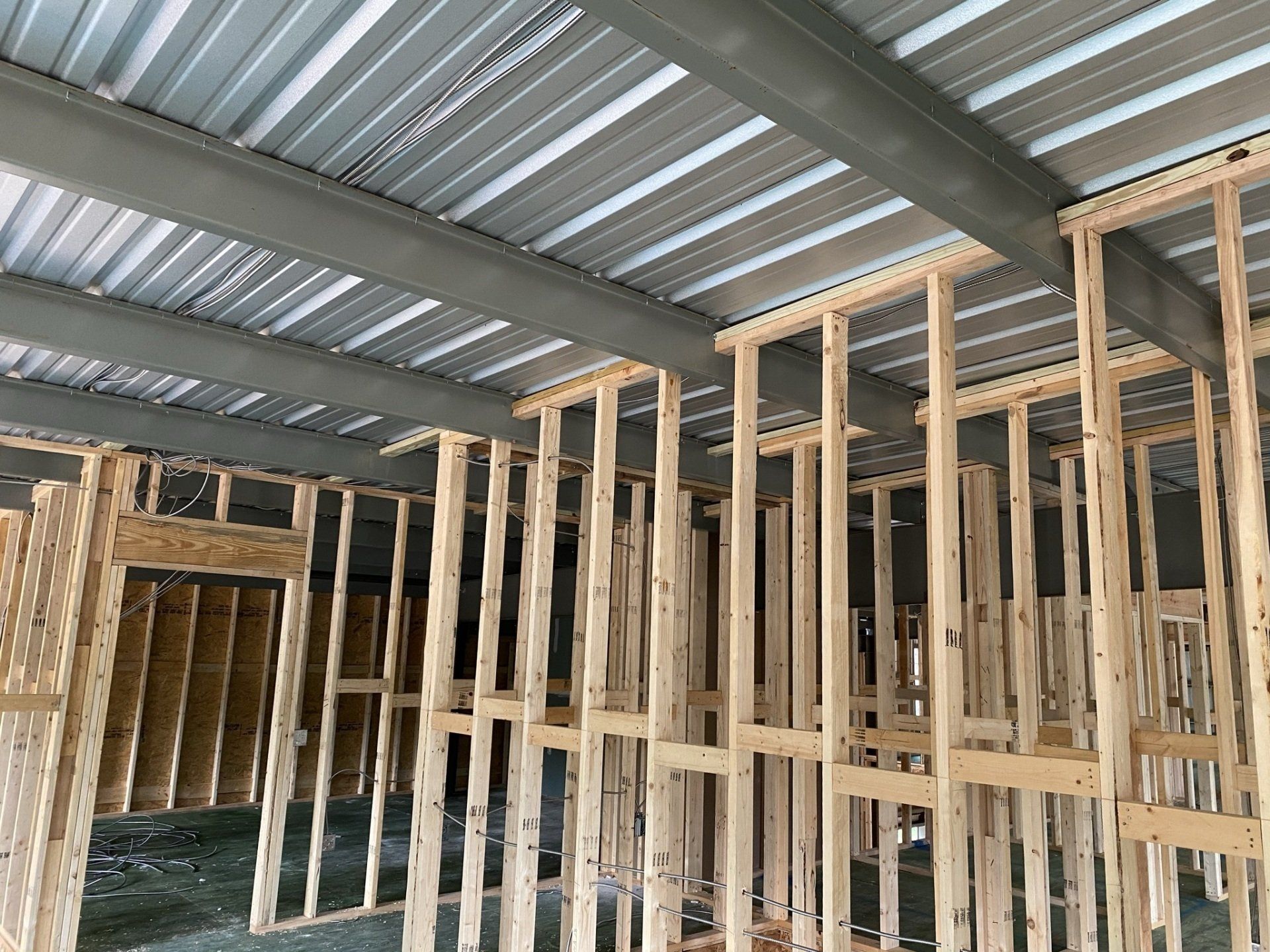 A building is being built with wooden beams and a metal roof.