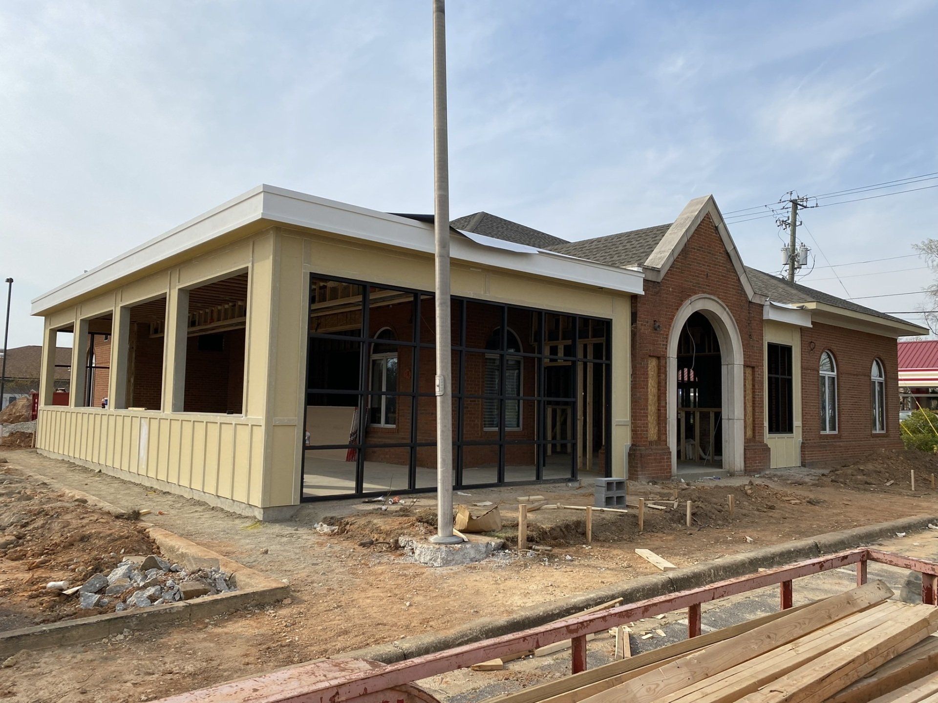 A building under construction with a lot of windows and a pole in front of it.