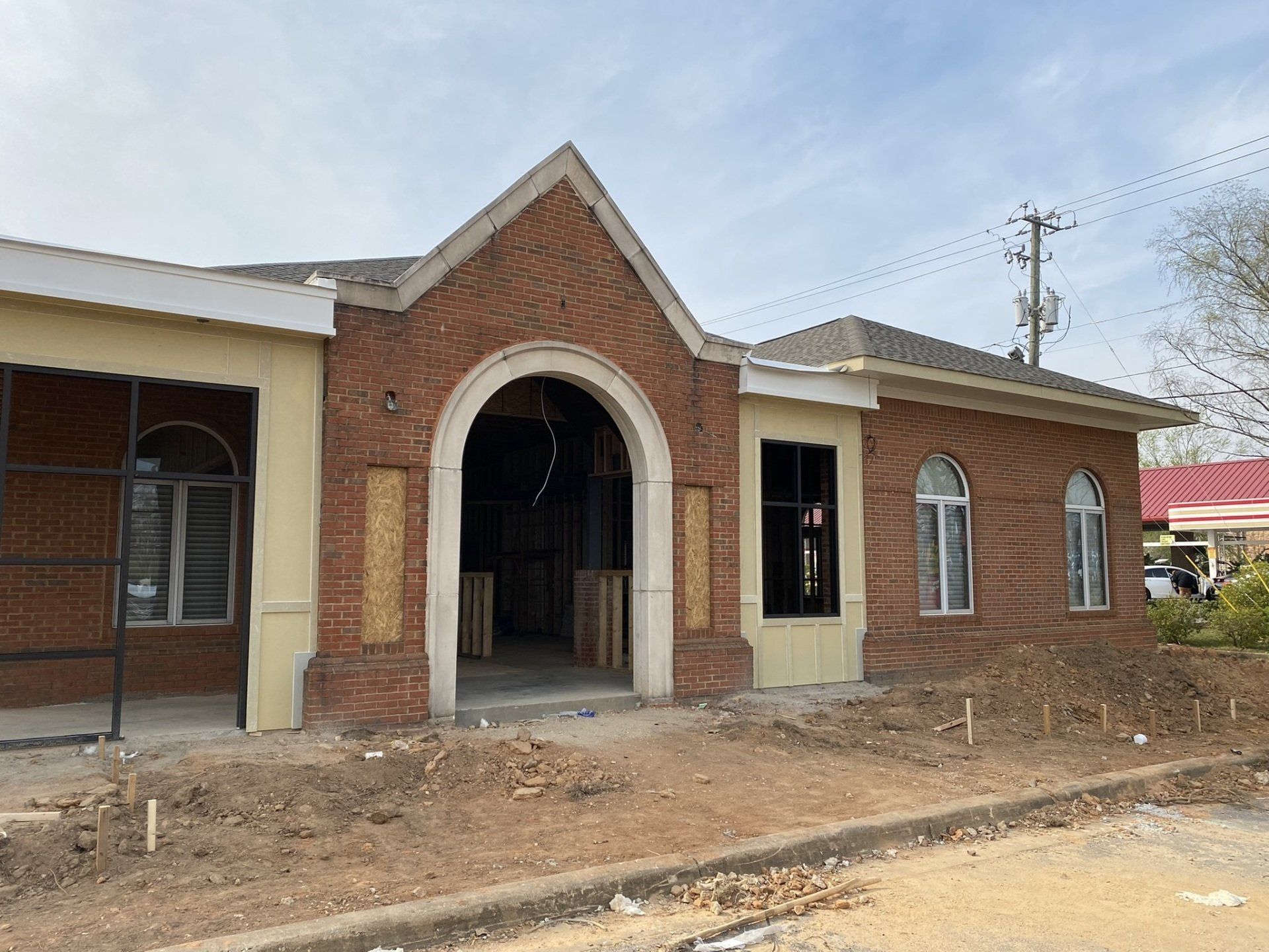 A brick building with a white roof is under construction.