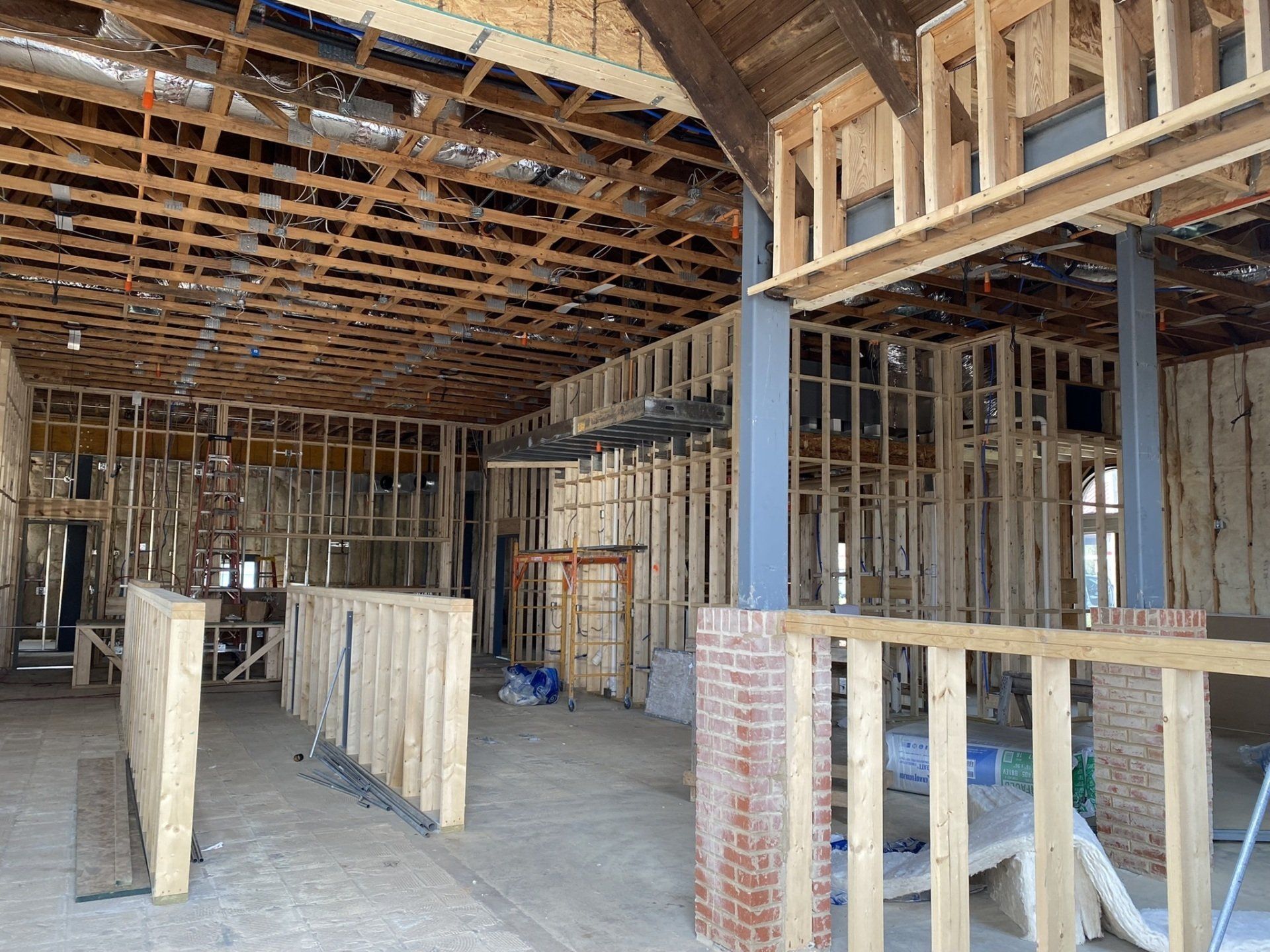 The inside of a building under construction with wooden beams and brick walls.
