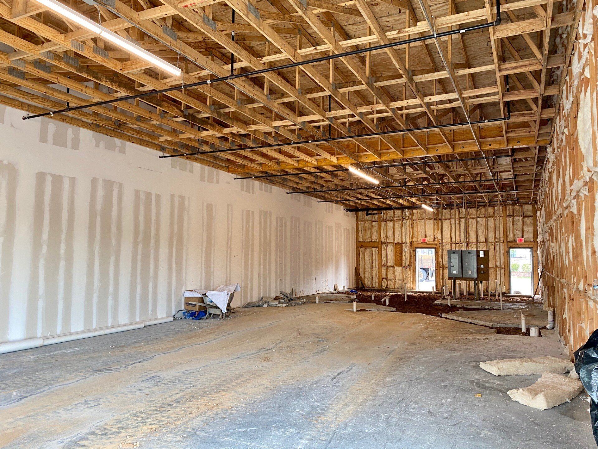 A large empty room with a wooden ceiling in a building under construction.