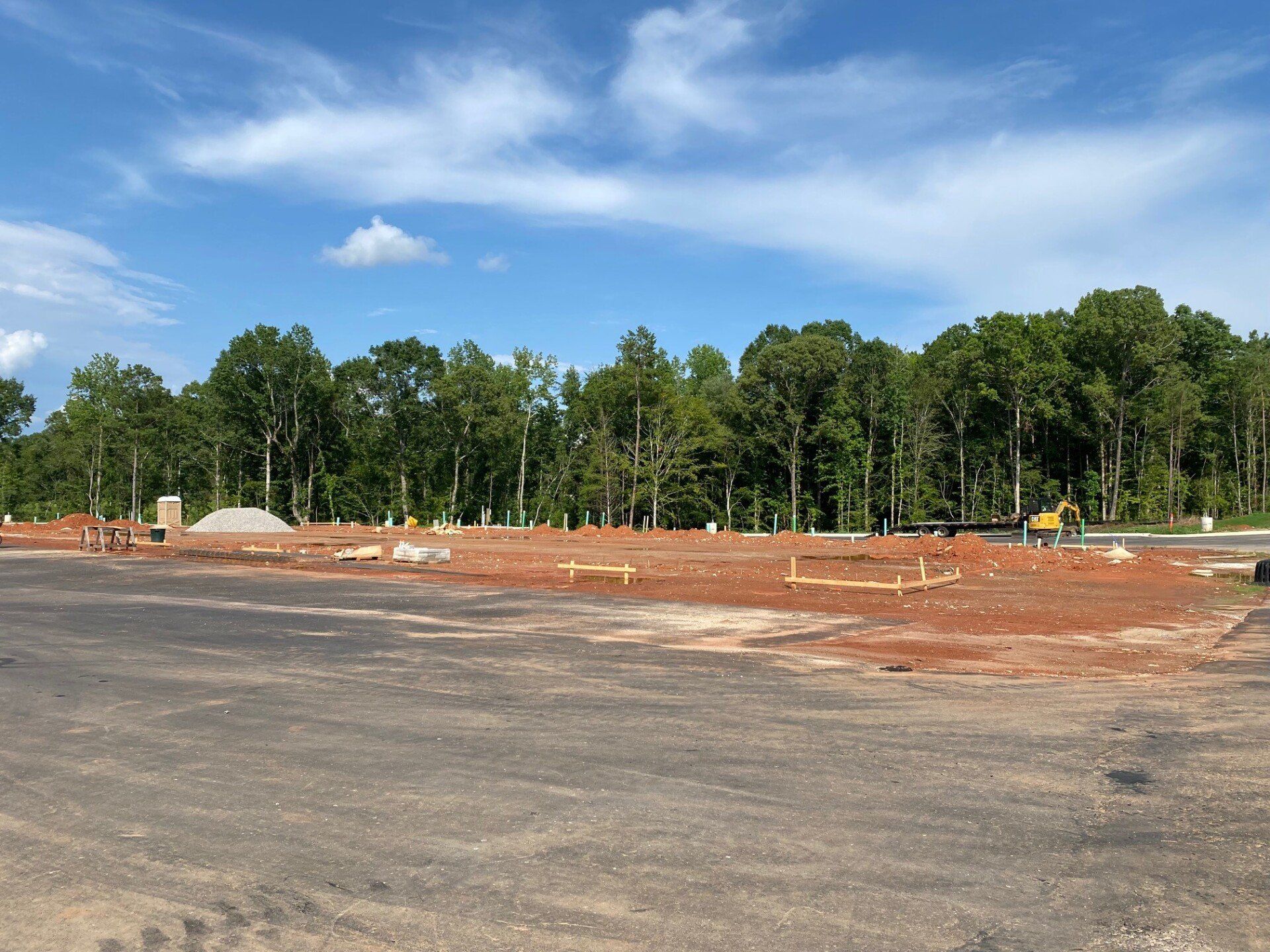 A construction site with a lot of dirt and trees in the background.