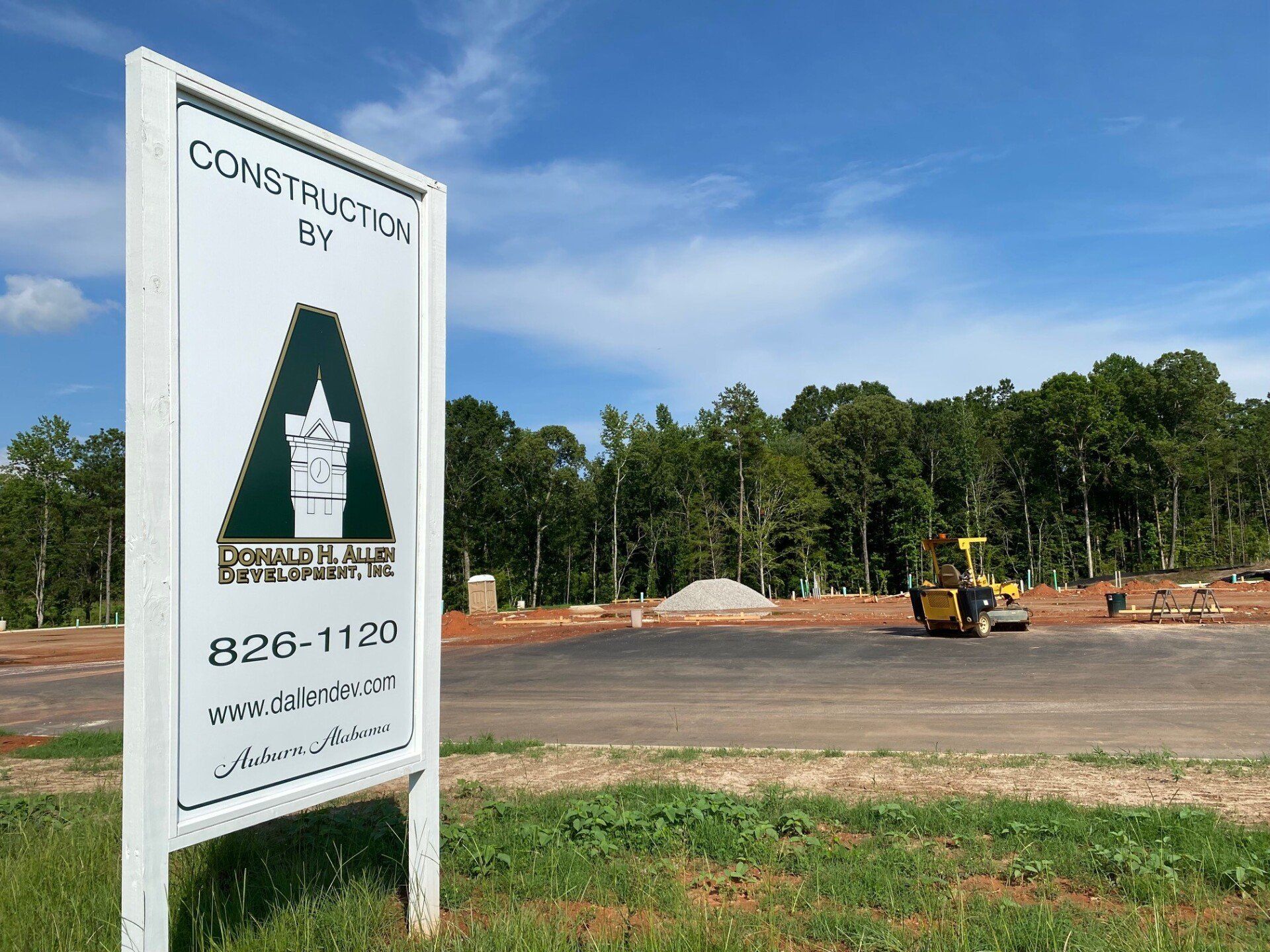 A construction sign is sitting in the middle of a grassy field.