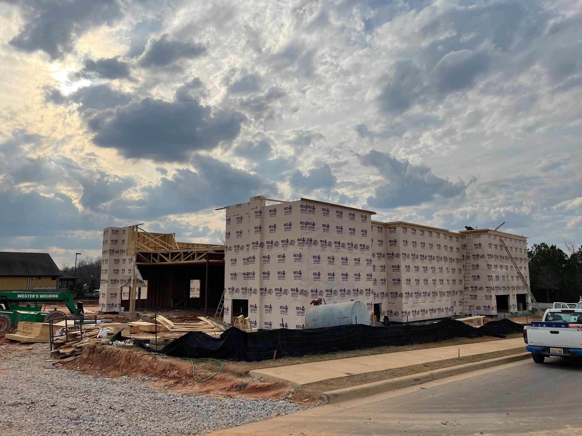 A large building is being built on the side of the road.