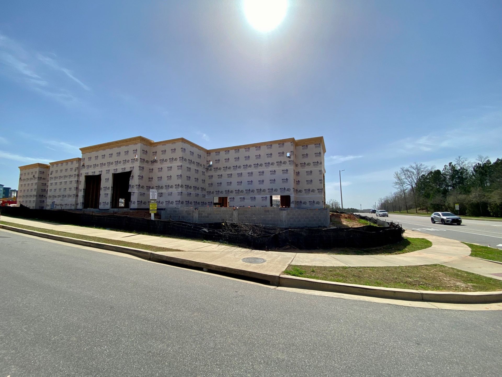 A large building is being built next to a road.