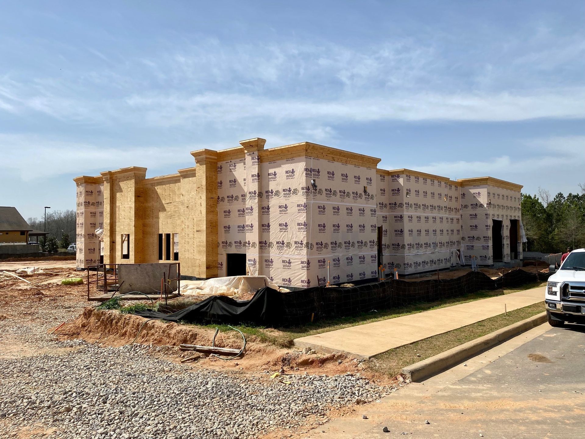 A building under construction with a truck parked in front of it.