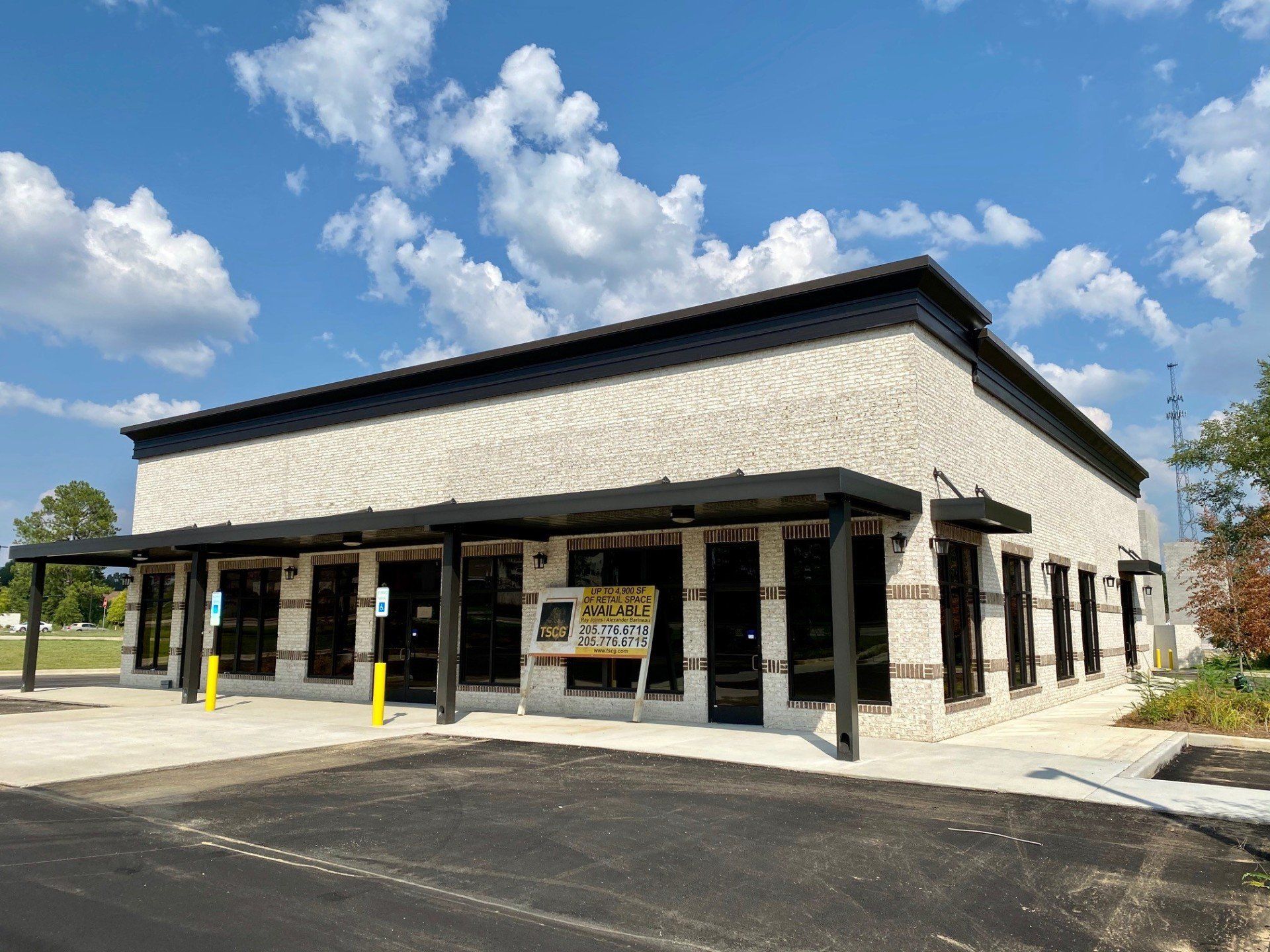A large brick building with a lot of windows and a parking lot in front of it.