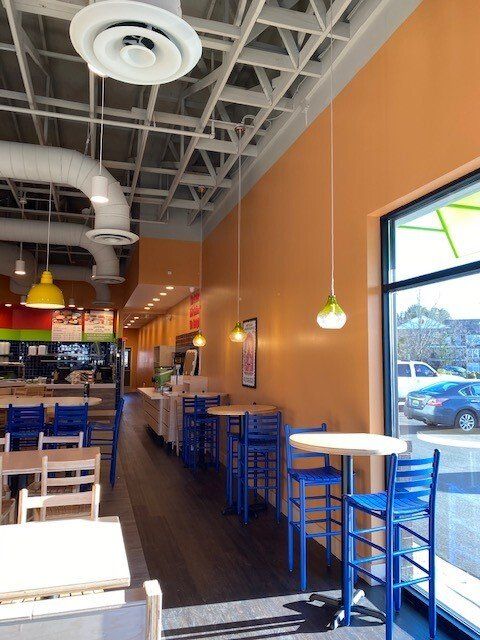 The inside of a restaurant with blue chairs and tables
