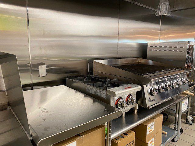 A kitchen with stainless steel appliances and boxes on the counter.
