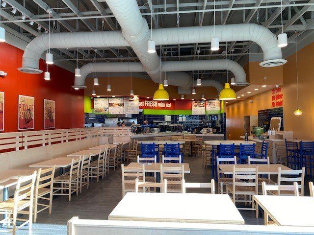 The inside of a restaurant with tables and chairs
