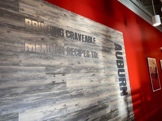 A wooden wall with a sign on it that says `` bringing craveable mexican recipes to auburn ''
