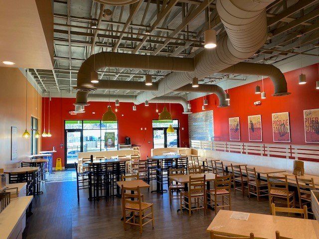 A restaurant with tables and chairs and red walls