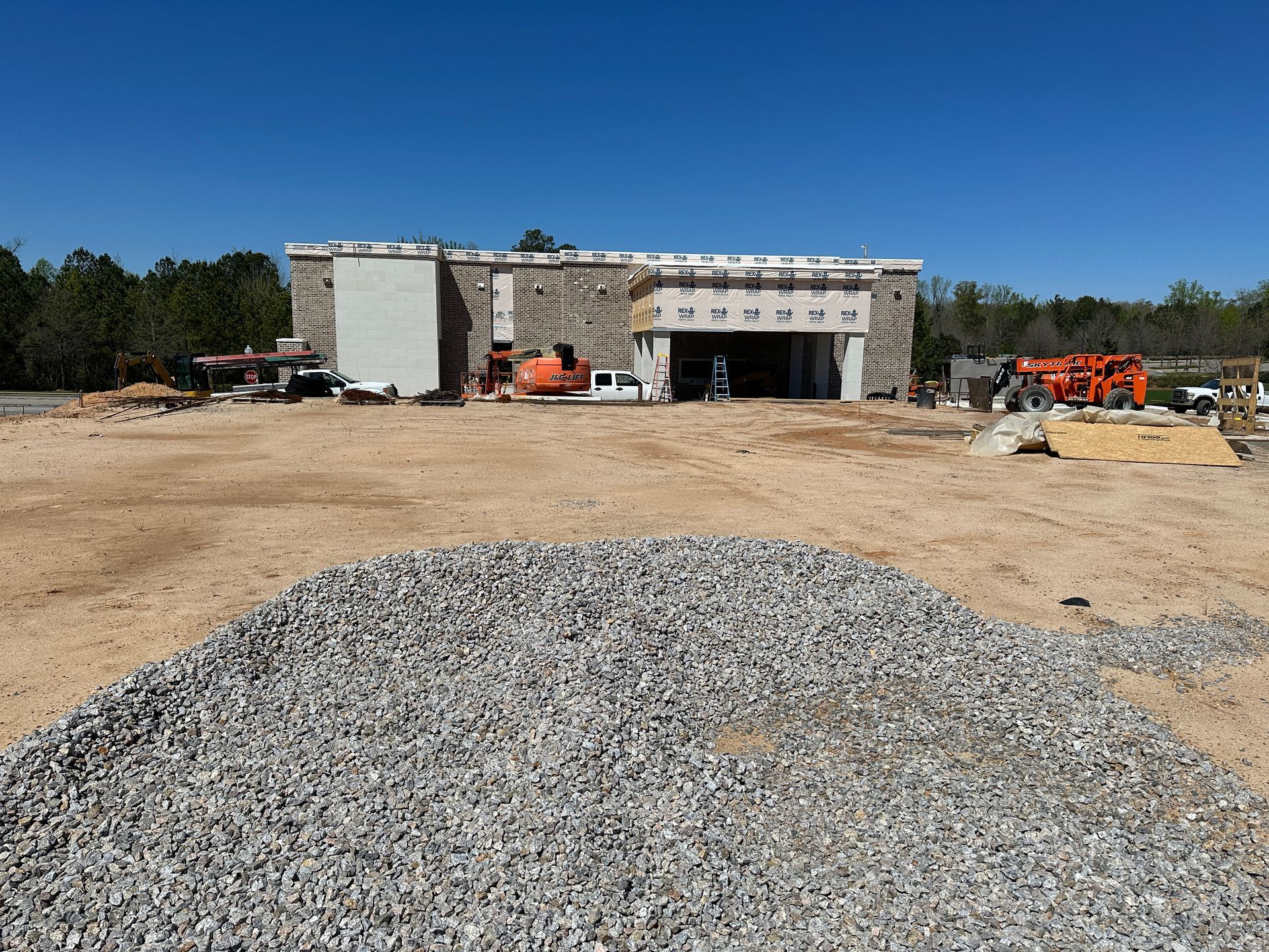 A large building under construction with a pile of gravel in front of it
